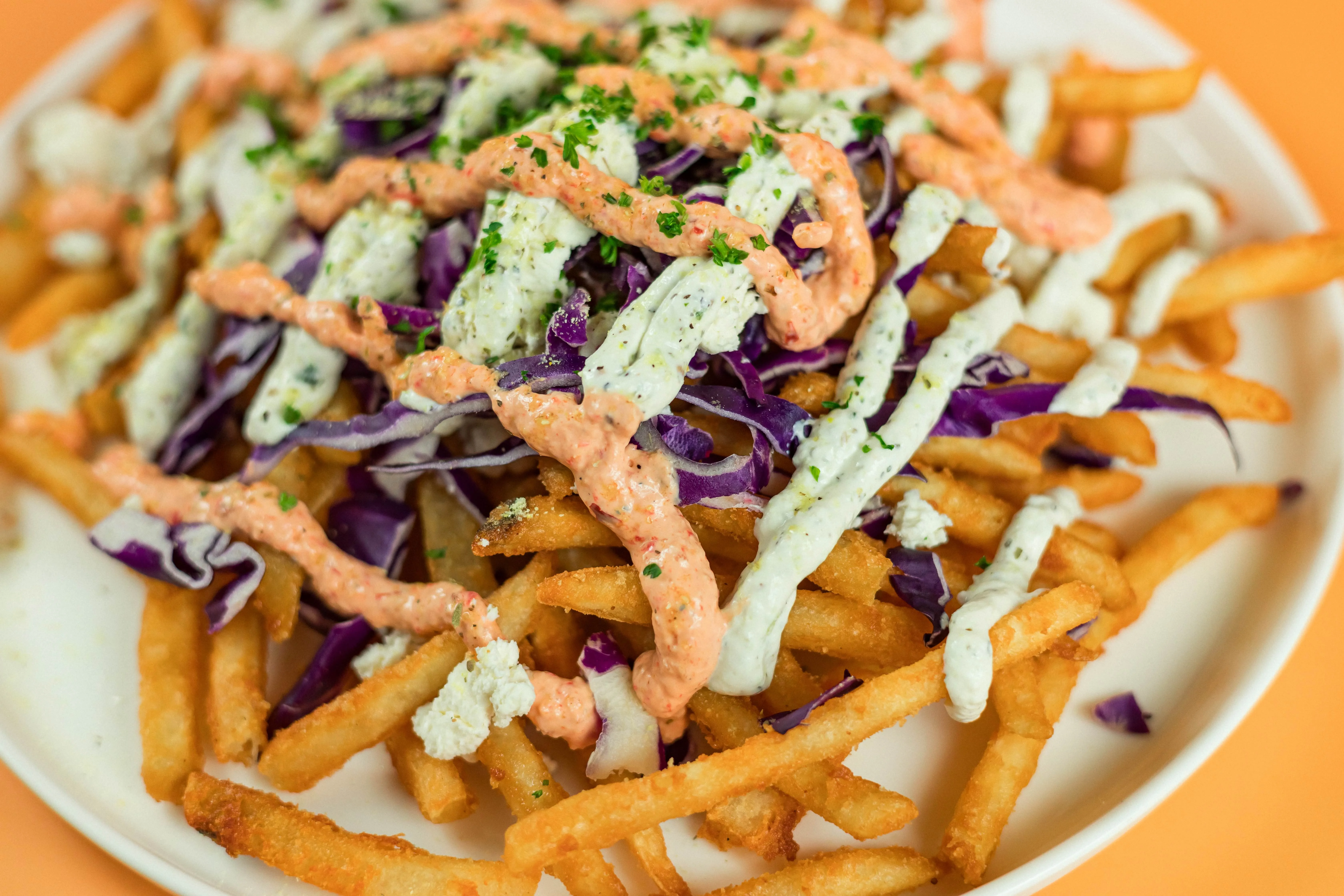 Santorini's loaded fries topped with purple cabbage, crispy onions, and creamy Mediterranean sauce