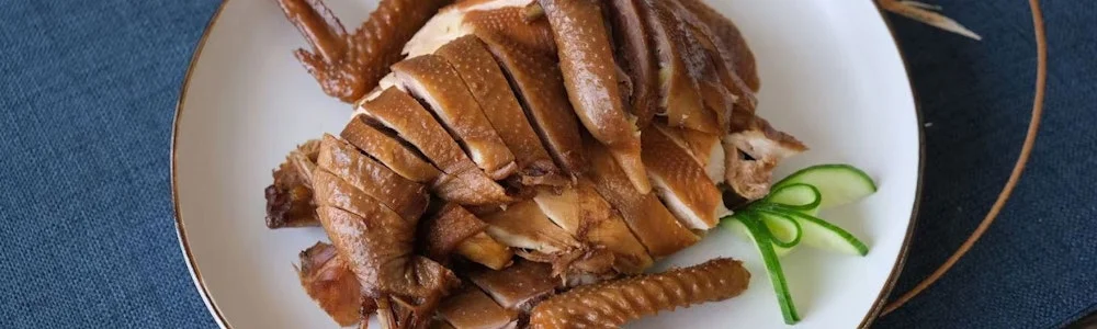 Sliced Hainanese chicken served with garnishes