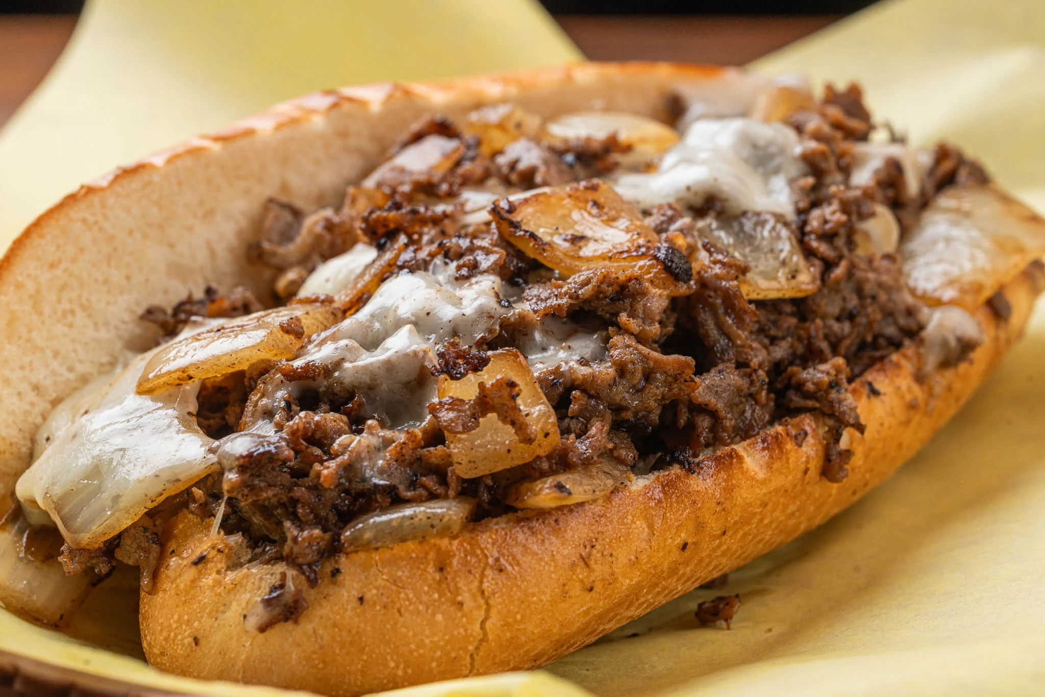 A traditional Philly cheesesteak sandwich with melted cheese and grilled onions.