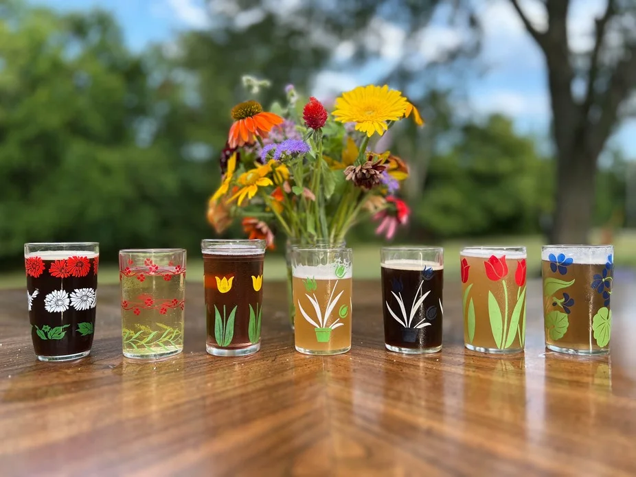 A drink labeled 'Cider Mill Margarita' served in a decorative glass, featuring ingredients like lime juice and a slice of dried apple.