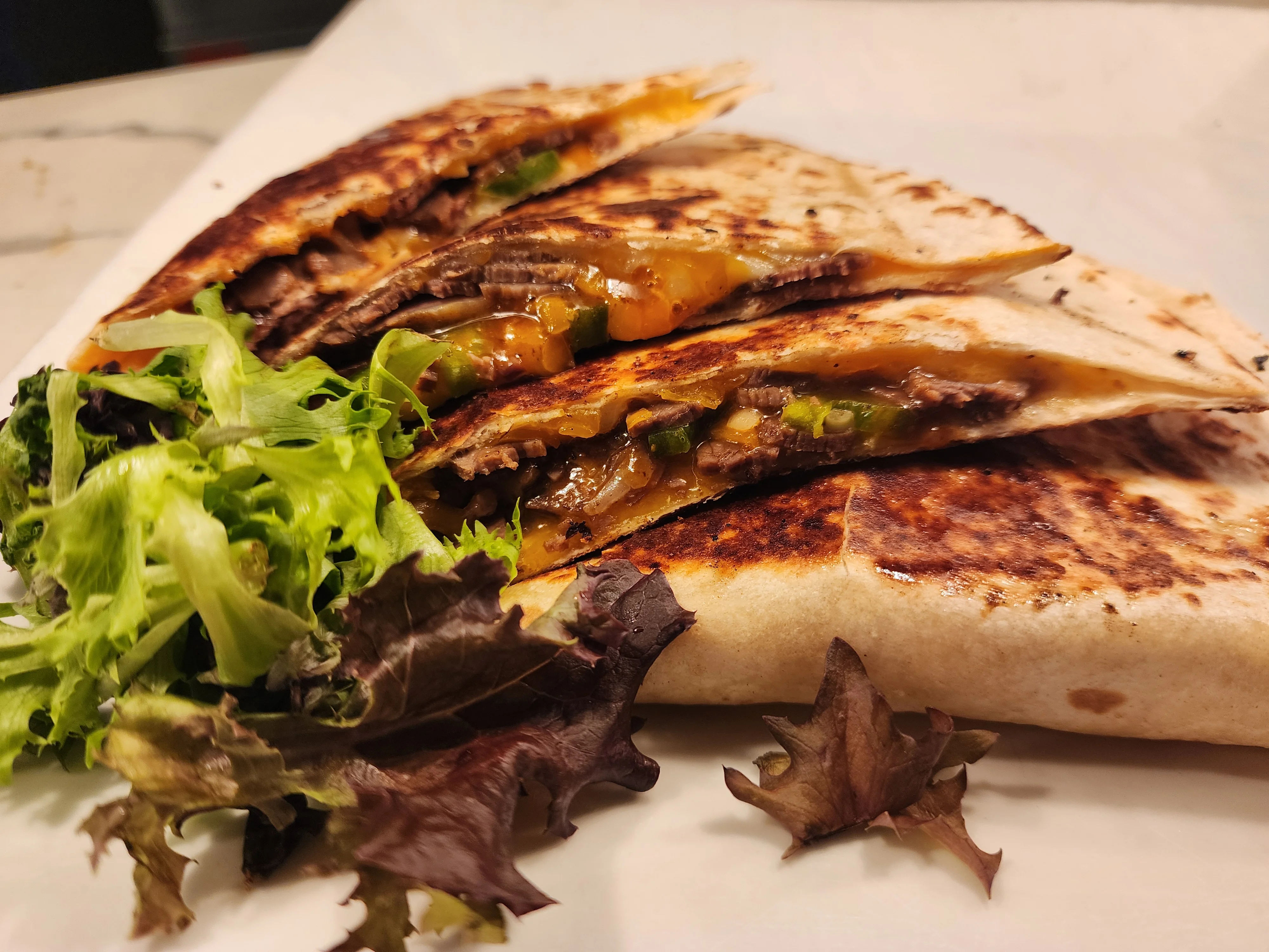 Grilled beef quesadilla with fresh greens