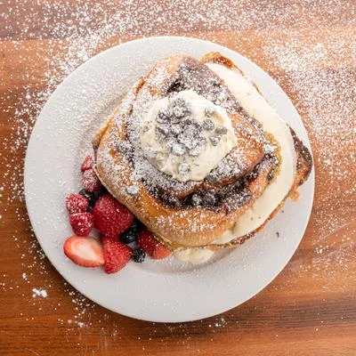 Fluffy French toast topped with whipped cream and fresh berries