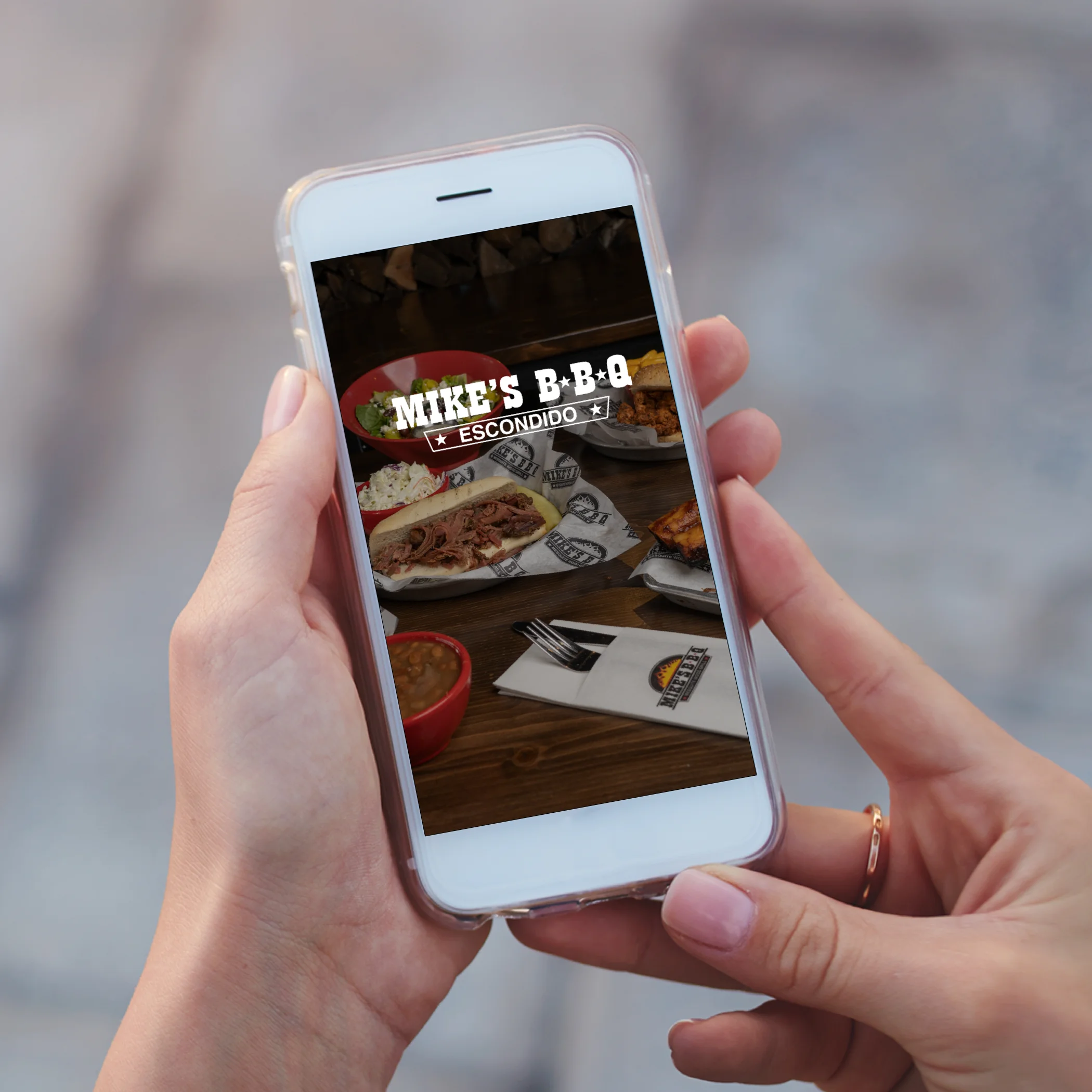 Person holding a phone displaying Mike's BBQ menu in Escondido.