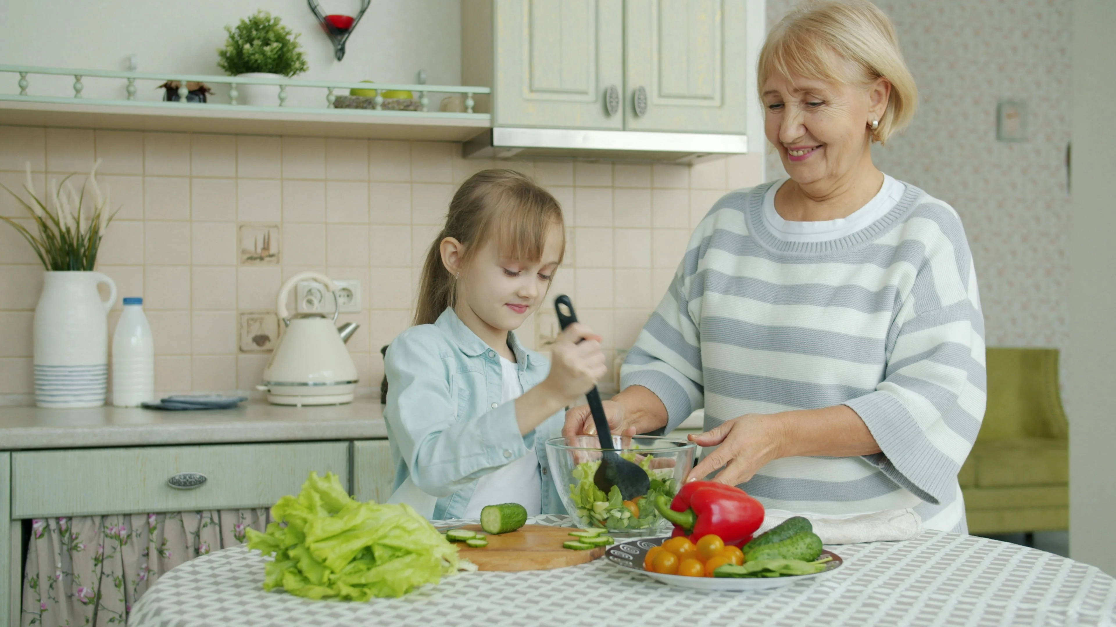 A grandmother and granddaughter making Mediterranean salad together. 