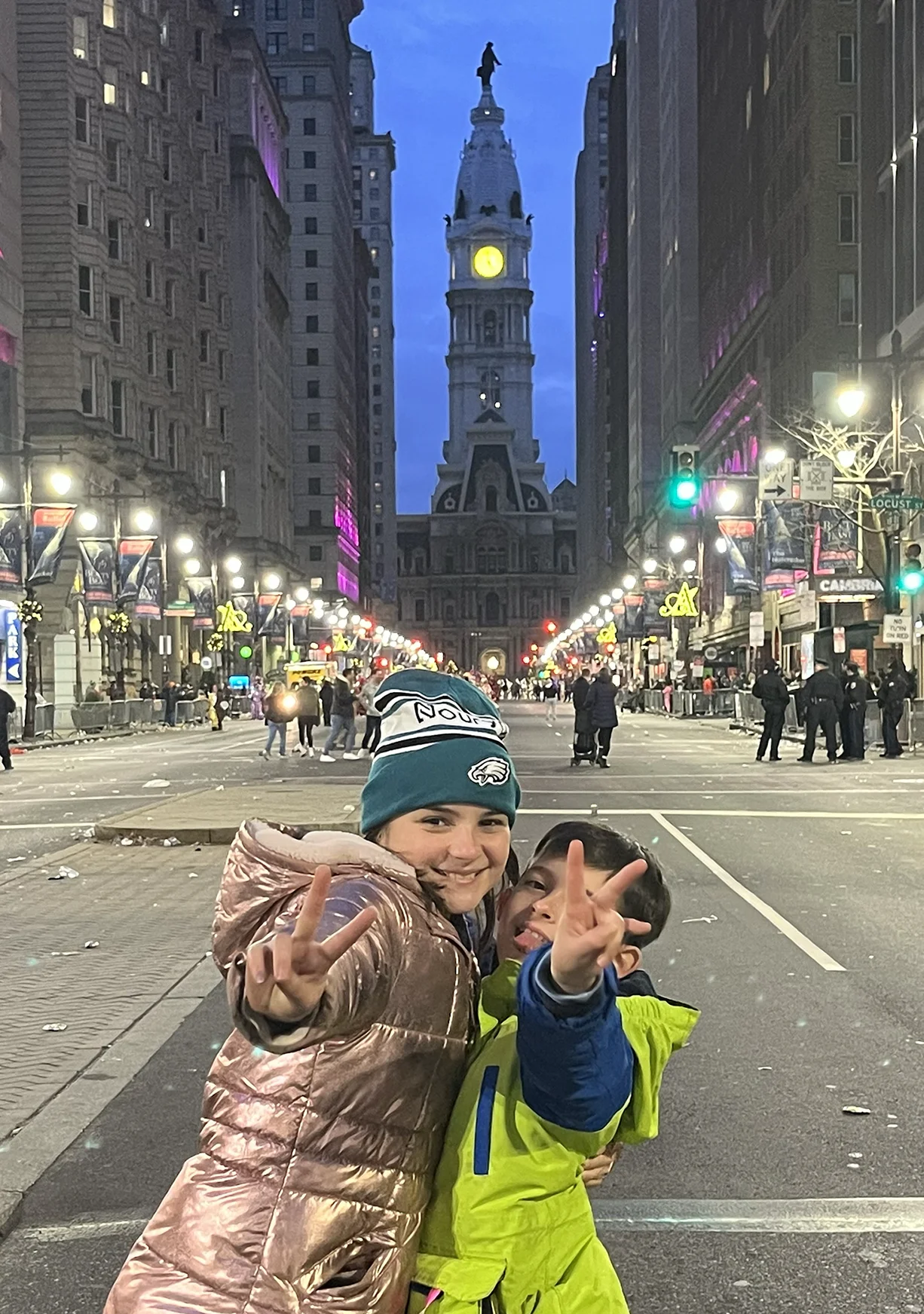 Children posing joyfully in a city street with historic buildings in the background