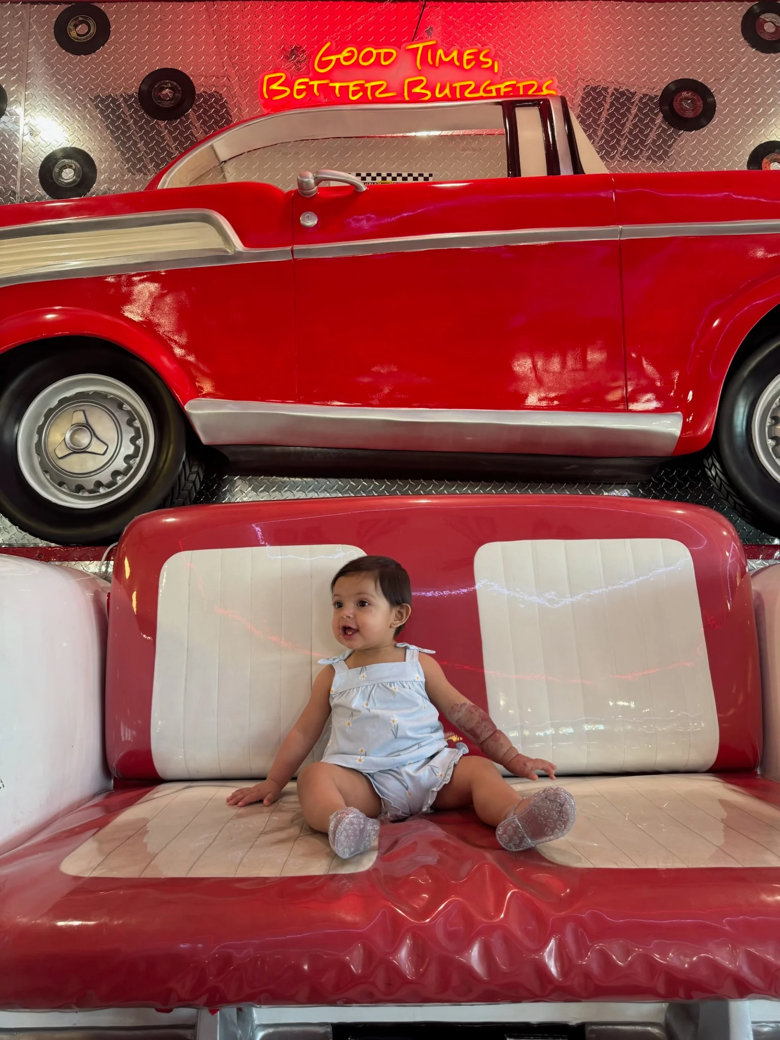 Child sitting in retro diner booth with vintage car decor