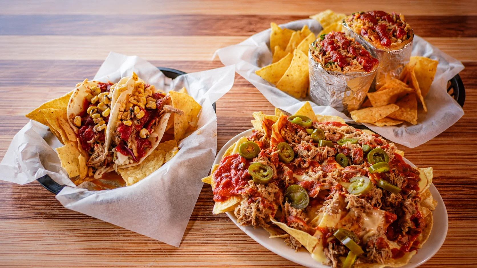 Loaded nachos with pulled pork and tacos in a vibrant setting