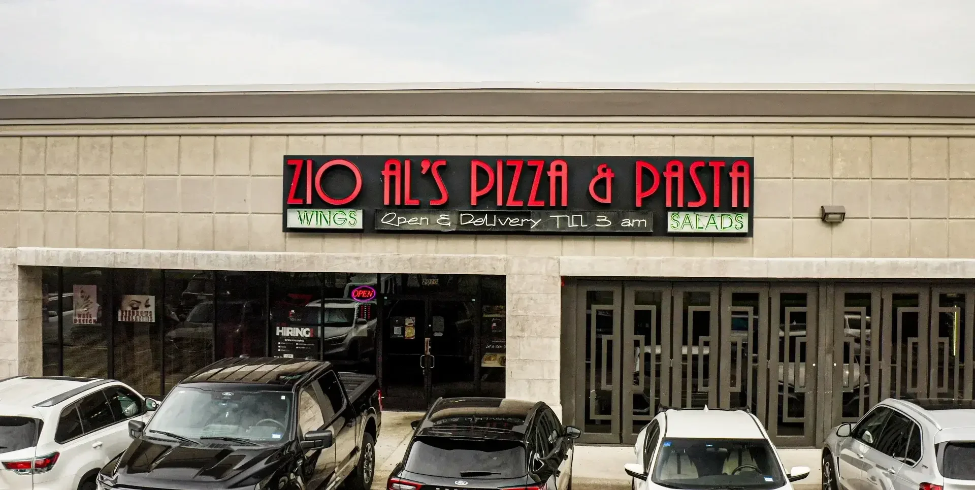 Exterior of Zio Al's Pizza & Pasta restaurant with neon signage