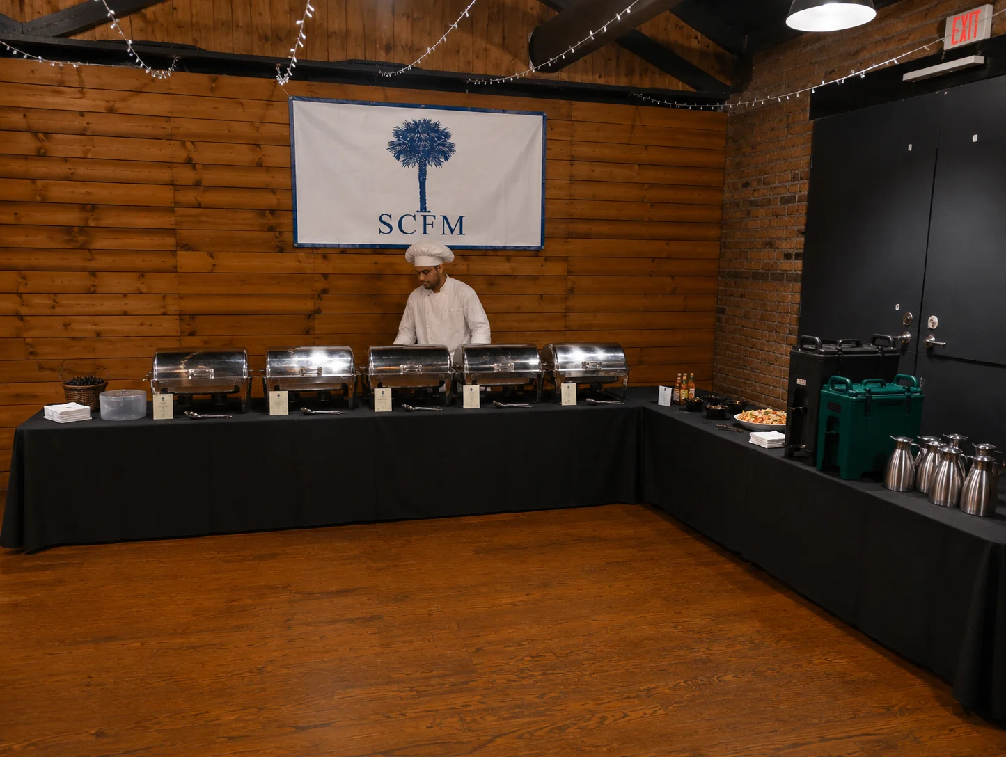 Buffet setup with chafing dishes and a salad bowl in a dining area.
