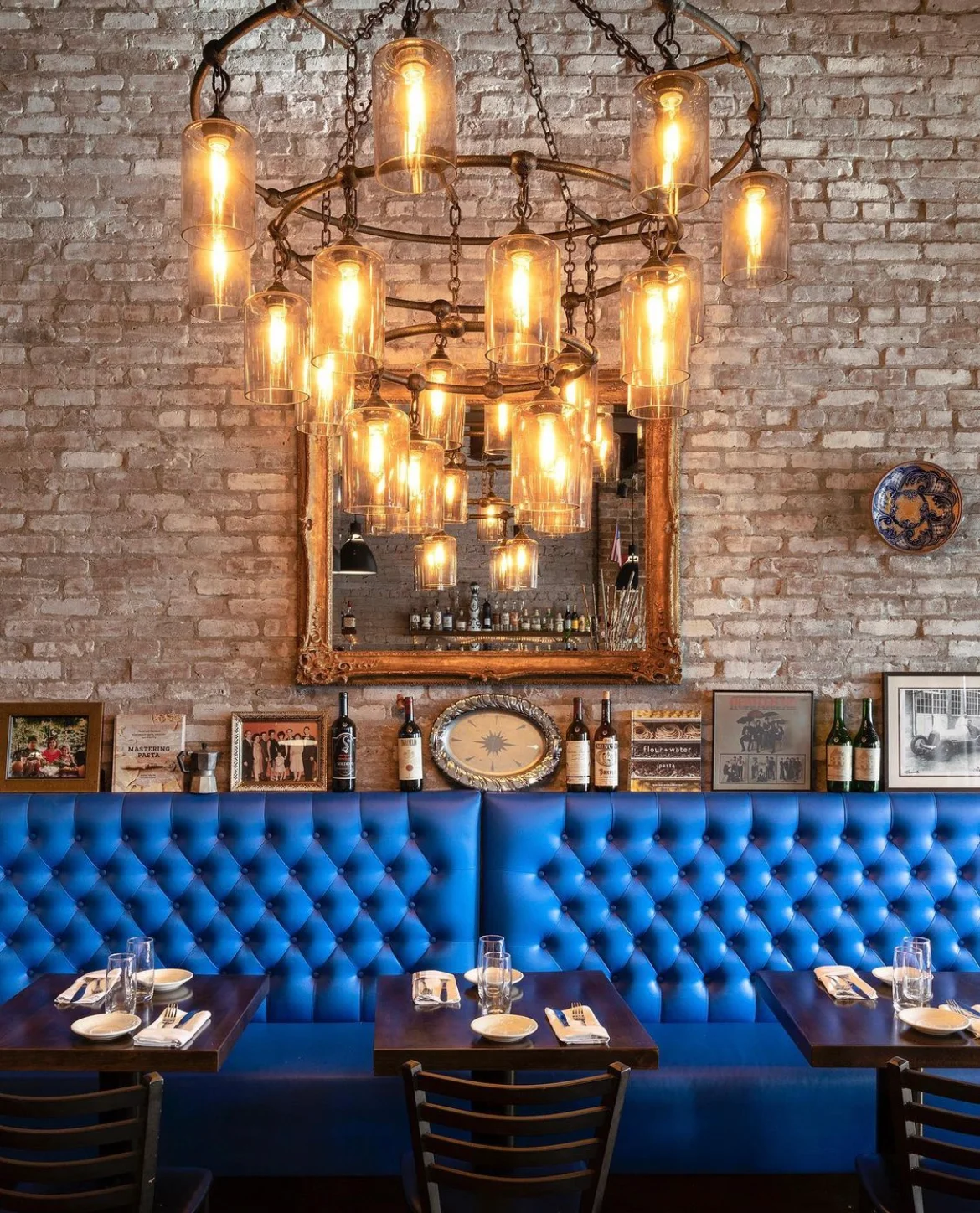 Cozy restaurant interior with blue tufted seating and warm lighting