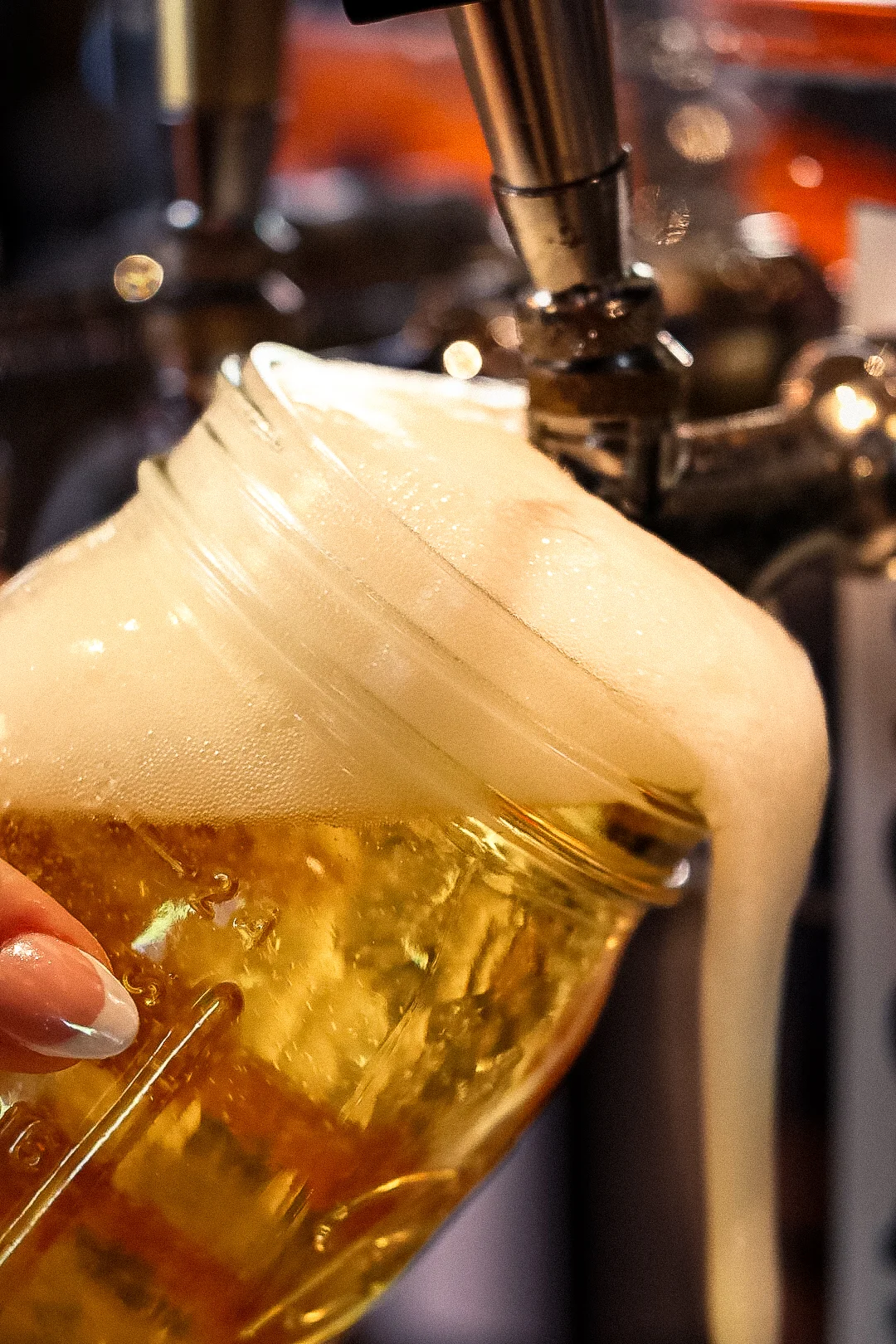 Pouring a cold beer into a mason jar at a bar