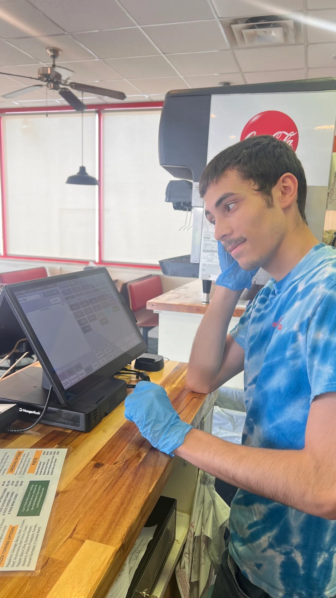Restaurant staff member at the counter using a POS system