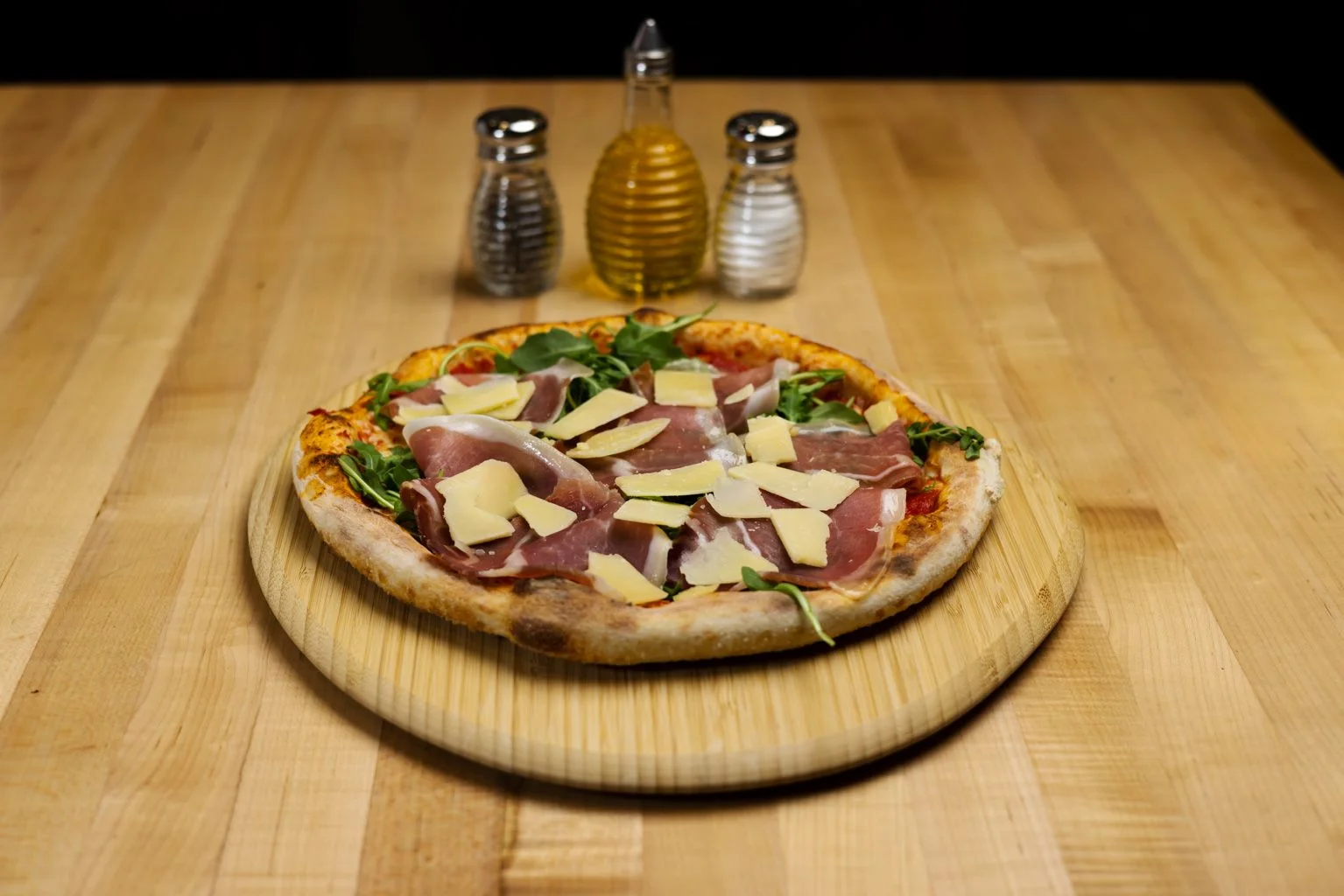 Italian prosciutto pizza with arugula and cheese