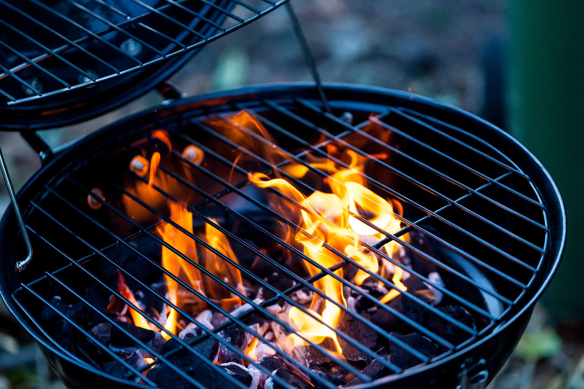 Close-up of a charcoal grill with flames and glowing coals.