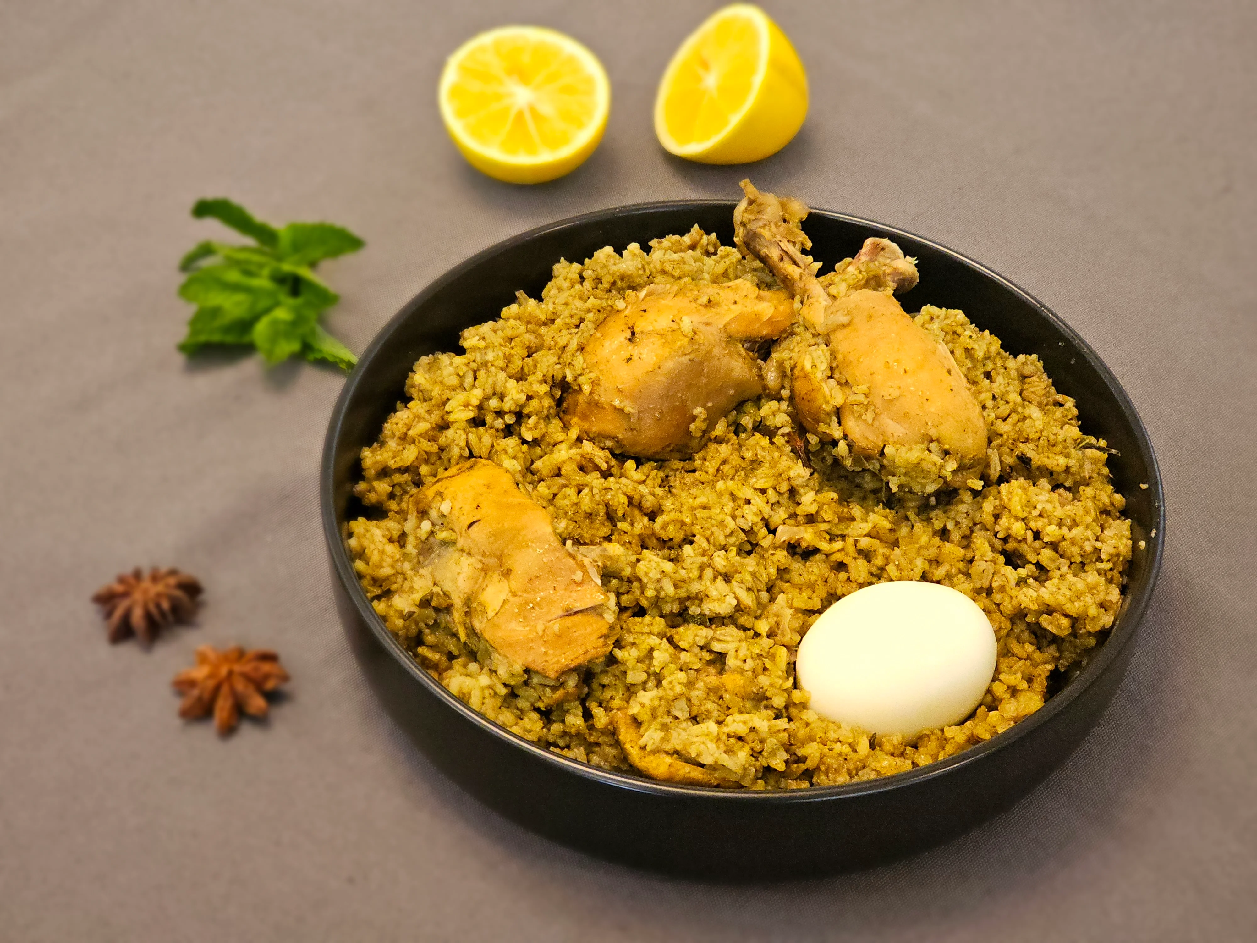 Traditional chicken biryani served with boiled egg and lemon