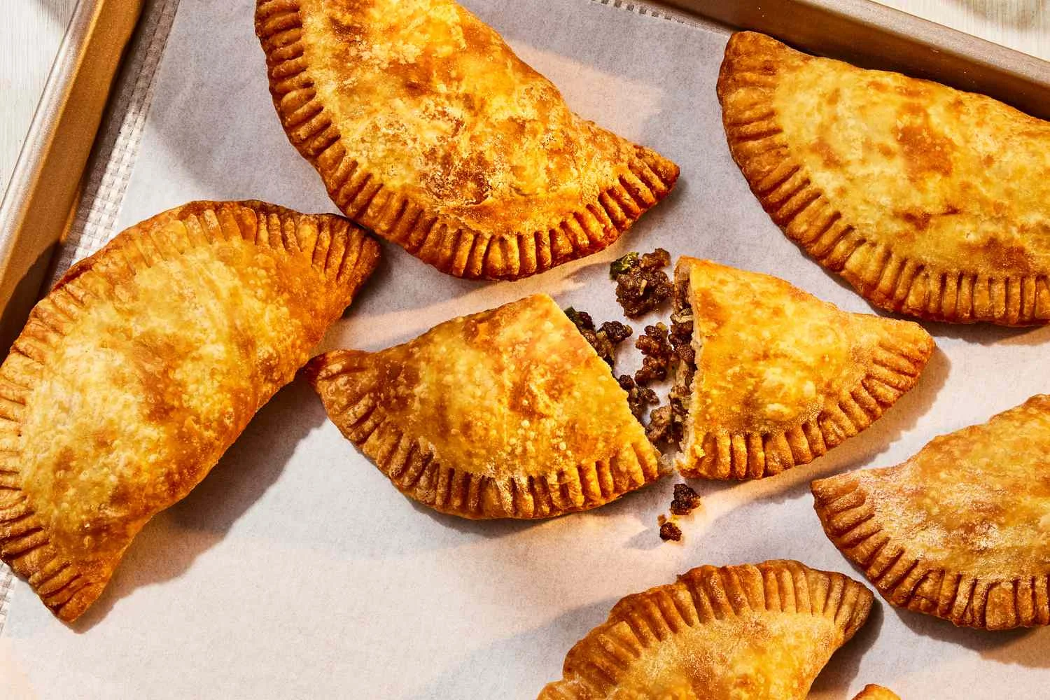 Golden empanadas on a baking tray