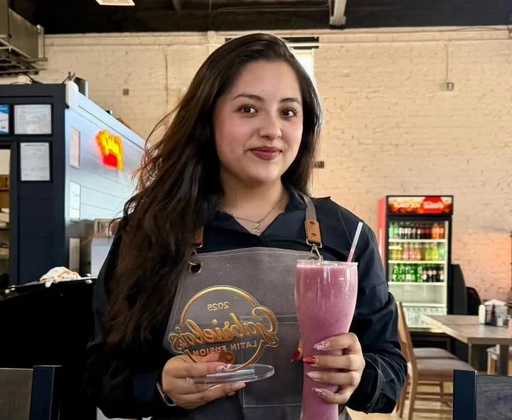 Waitress holding a vibrant smoothie in a cozy restaurant setting