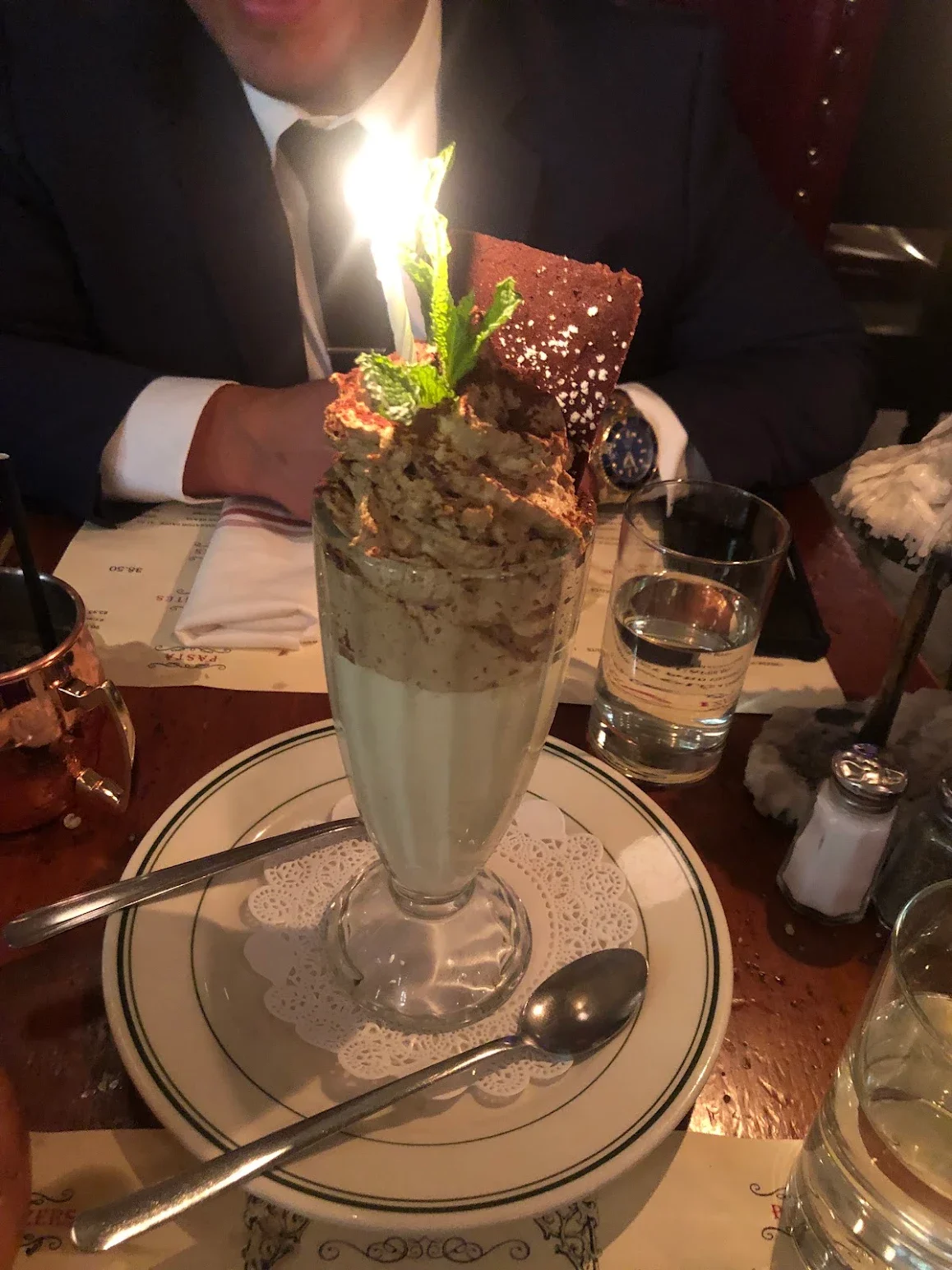 Decadent chocolate mousse dessert with candle and mint garnish