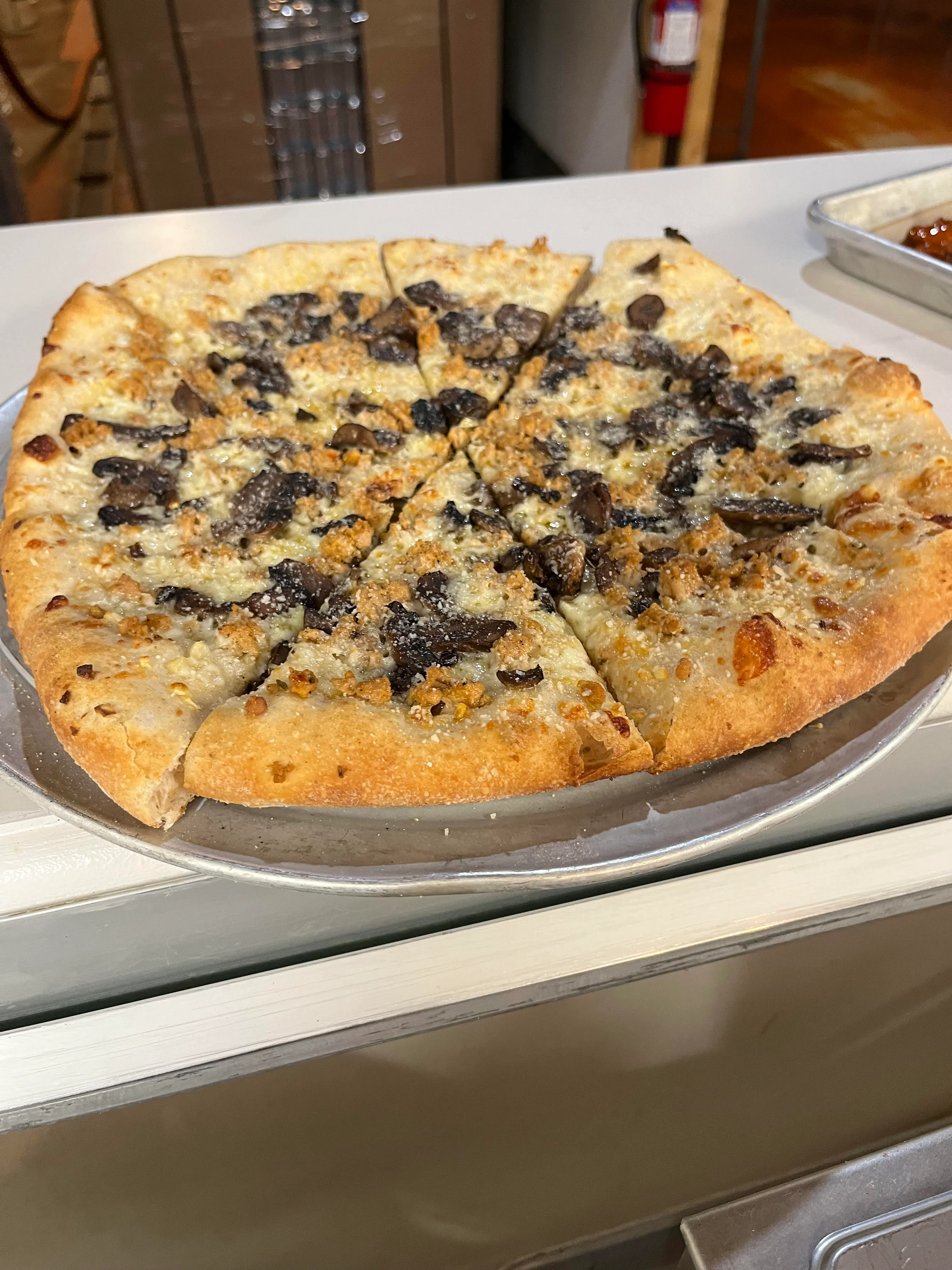Mushroom pizza with a crispy crust served on a silver platter