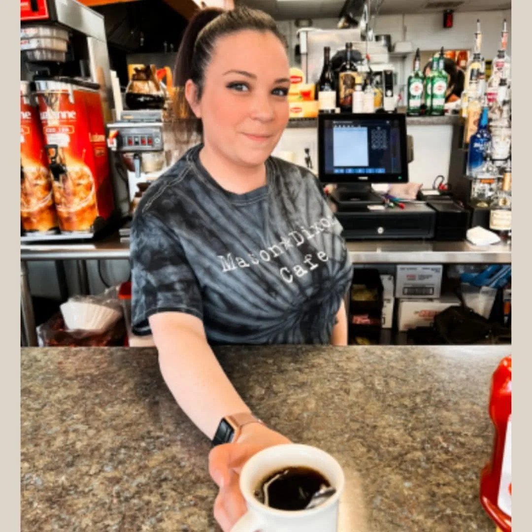 Barista serving coffee at a cozy cafe counter