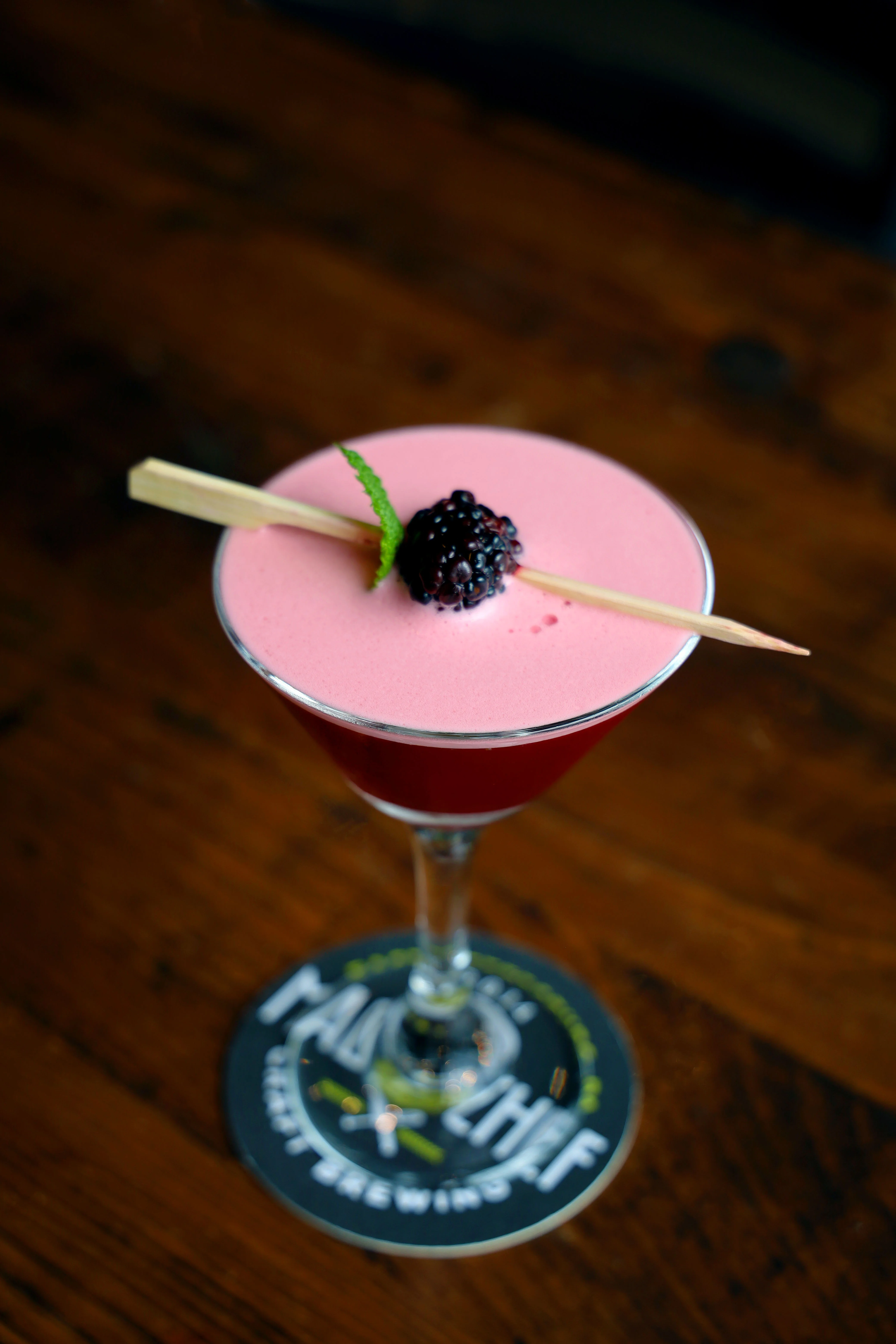 A refreshing blackberry cocktail garnished with a lemon twist.
