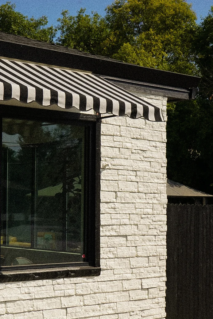 Exterior view of a restaurant with striped awning and modern design