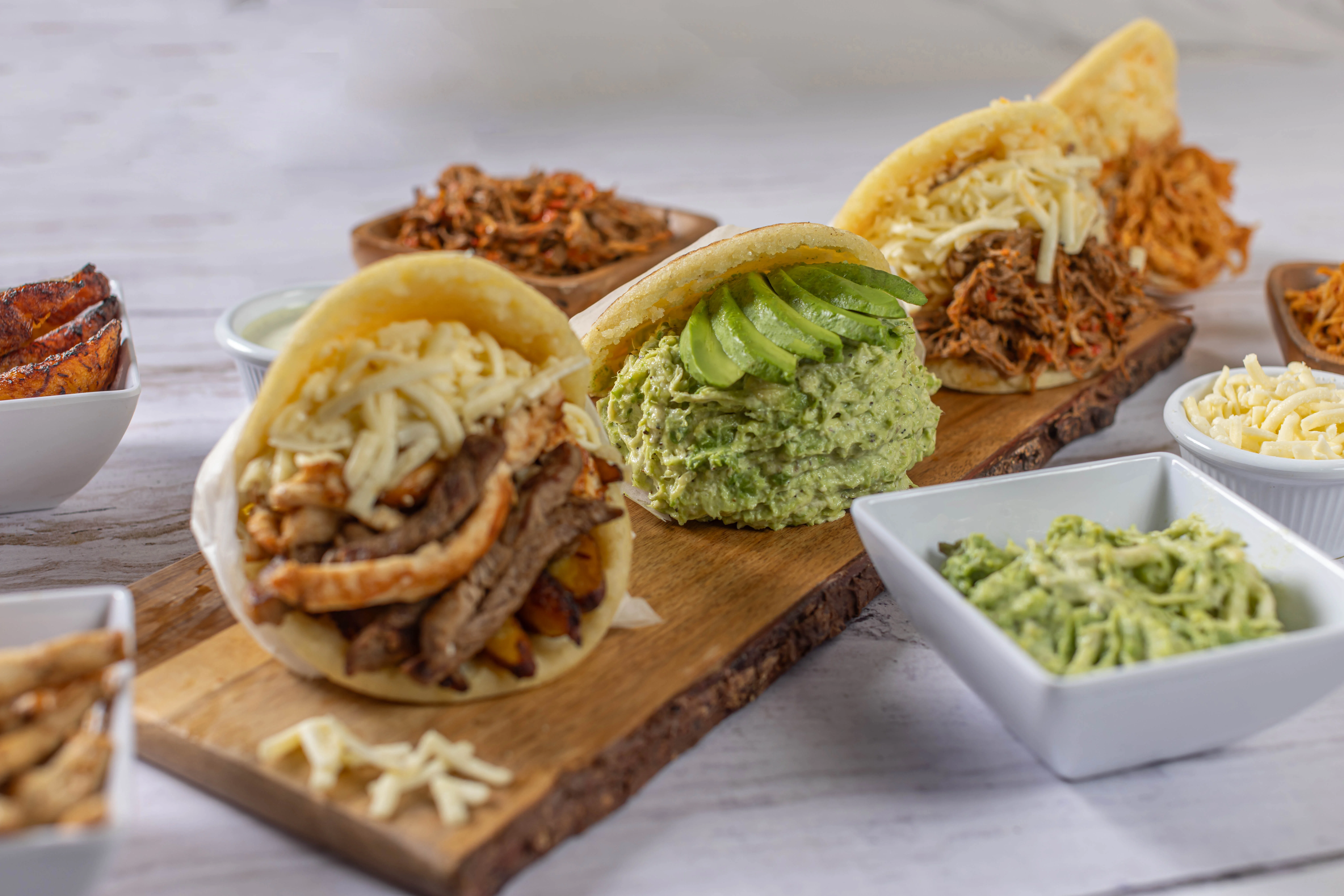 A delicious variety of freshly made Venezuelan arepas from El Budare Cafe, generously stuffed with steak, chicken salad, and shredded beef.