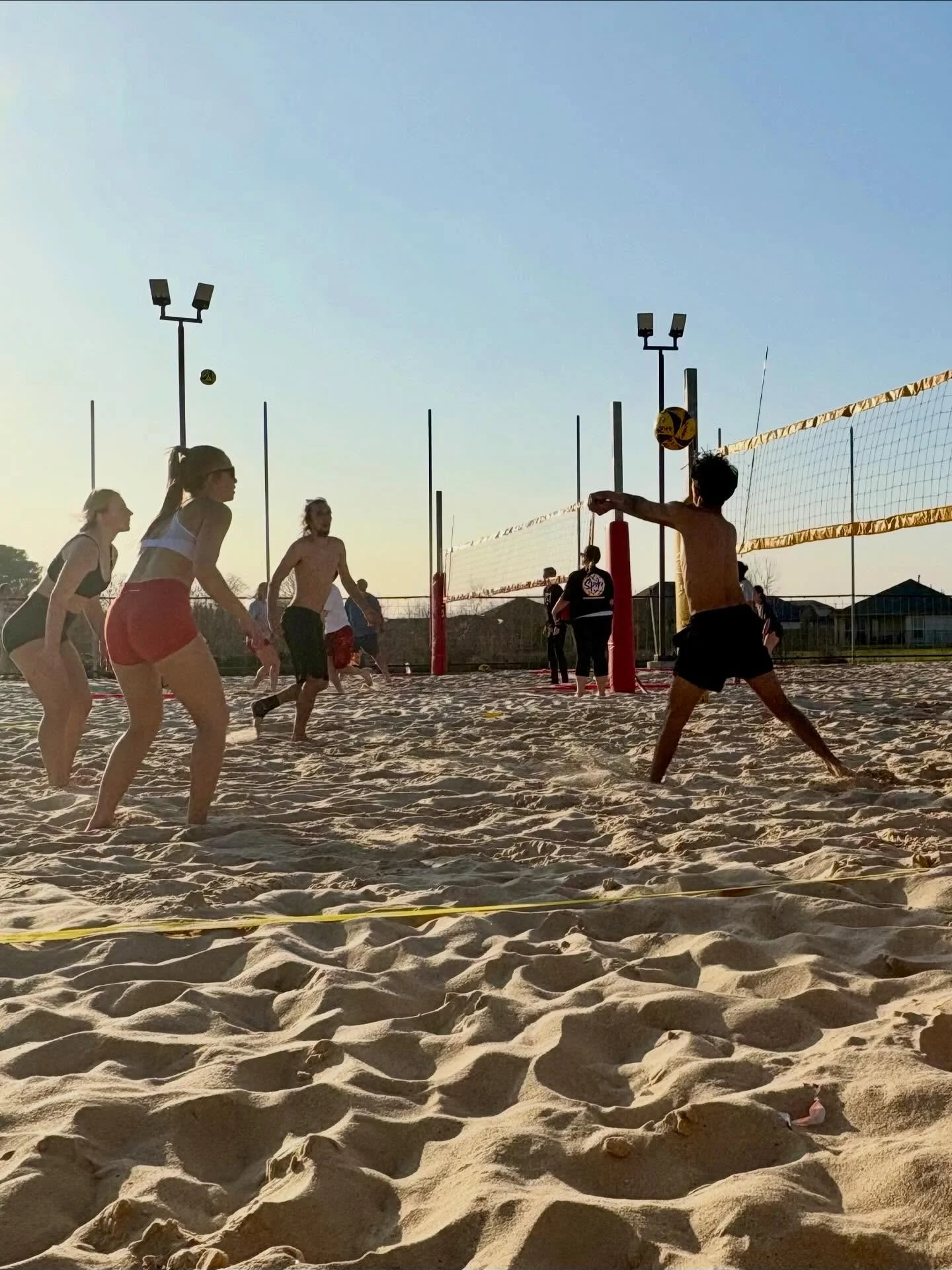 A volleyball game in progress with players on the court.