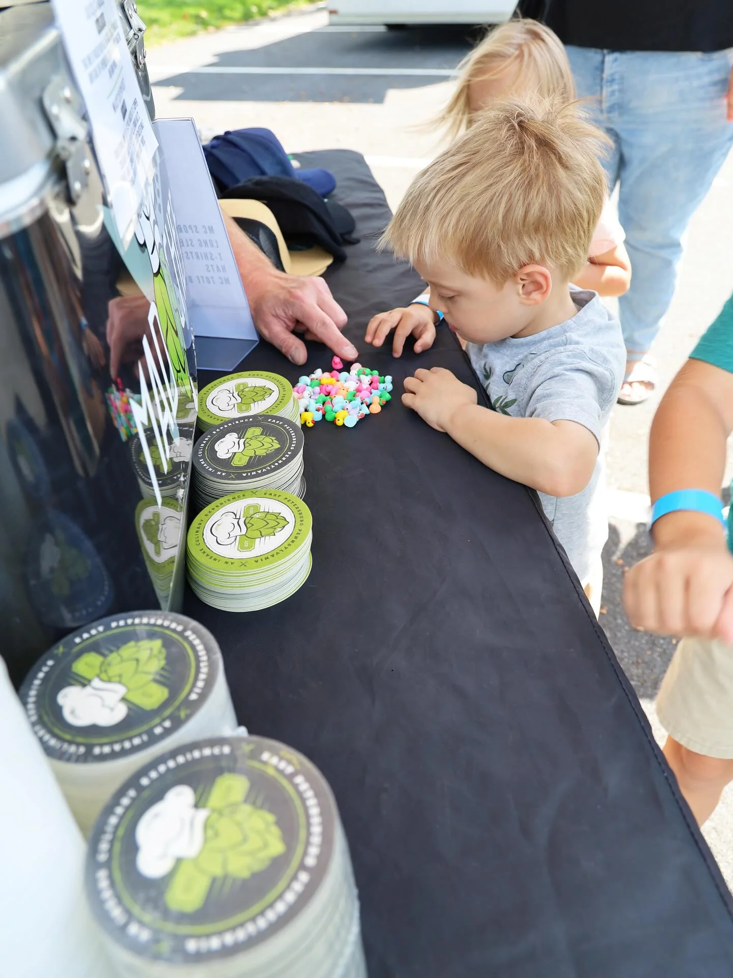 Child playing with colorful toys at a food festival booth