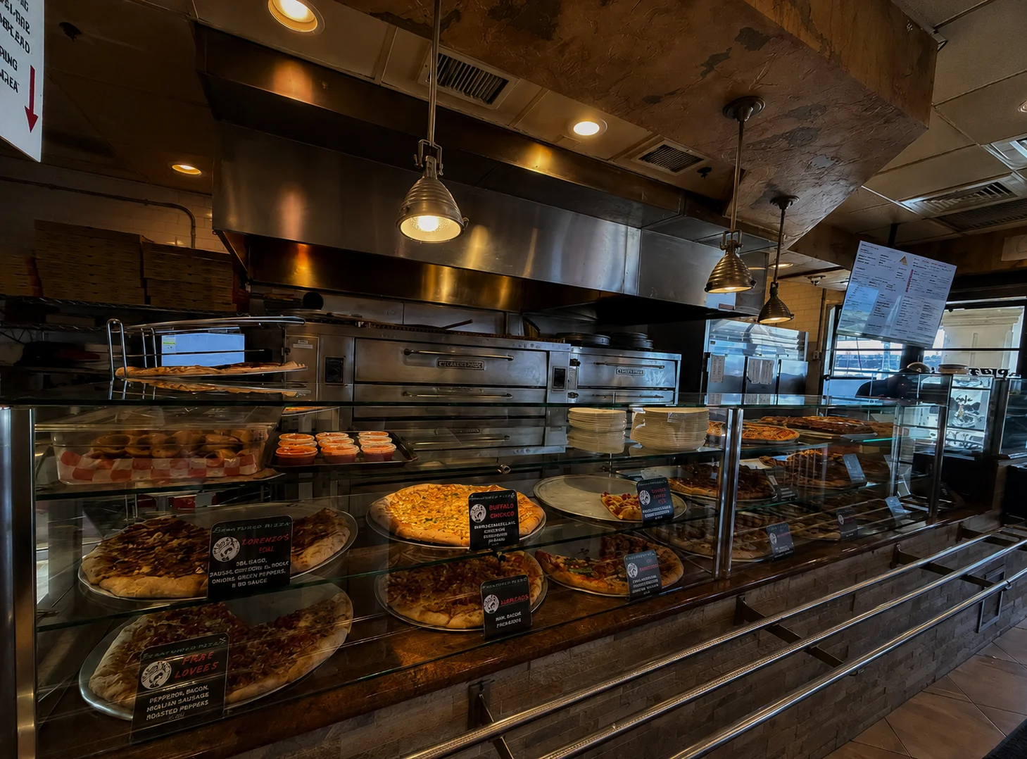 Display of various pizzas in a casual pizzeria setting