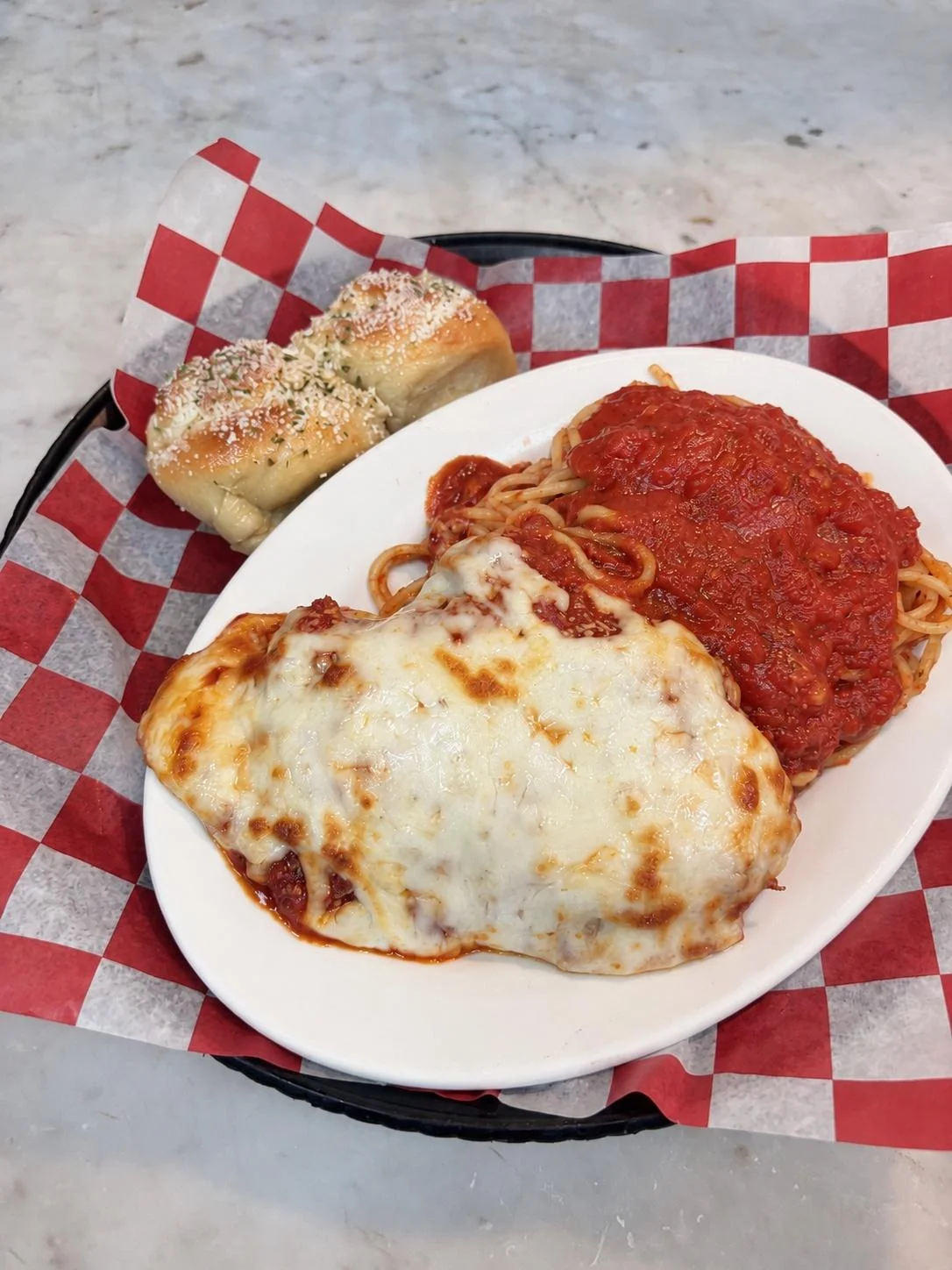 Pasquale’s breaded chicken Parmesan dinner with pasta and garlic rolls