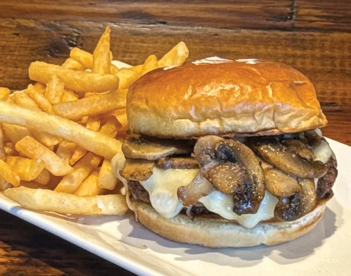 Juicy cheeseburger with sautéed mushrooms and fries