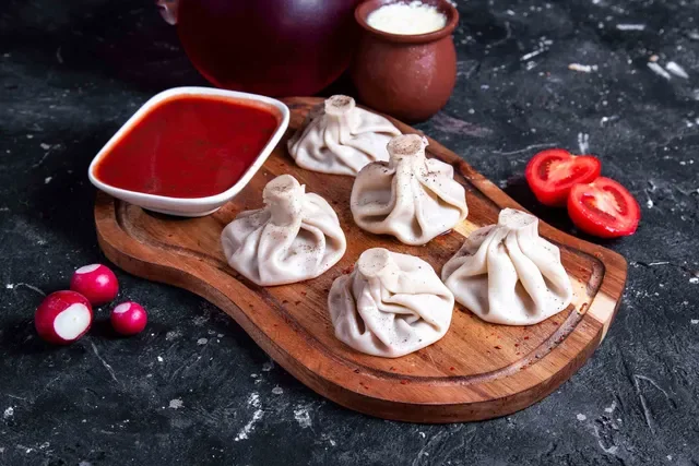 Georgian khinkali dumplings served with spicy sauce