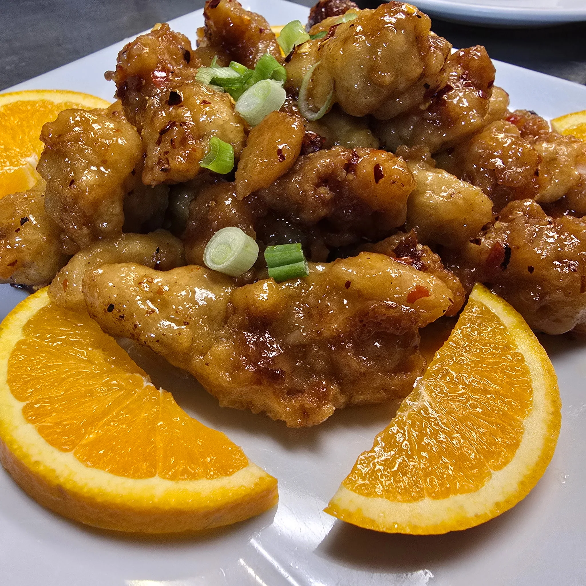 Crispy orange chicken served with fresh orange slices