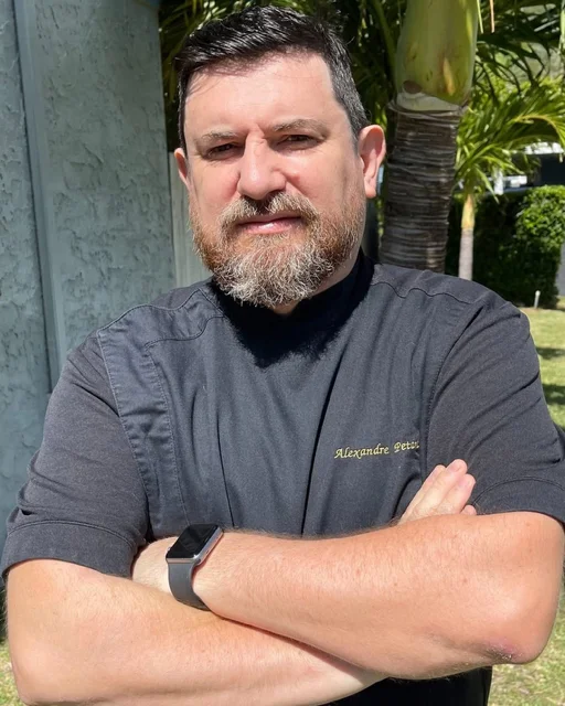Chef posing confidently outdoors in a professional kitchen uniform