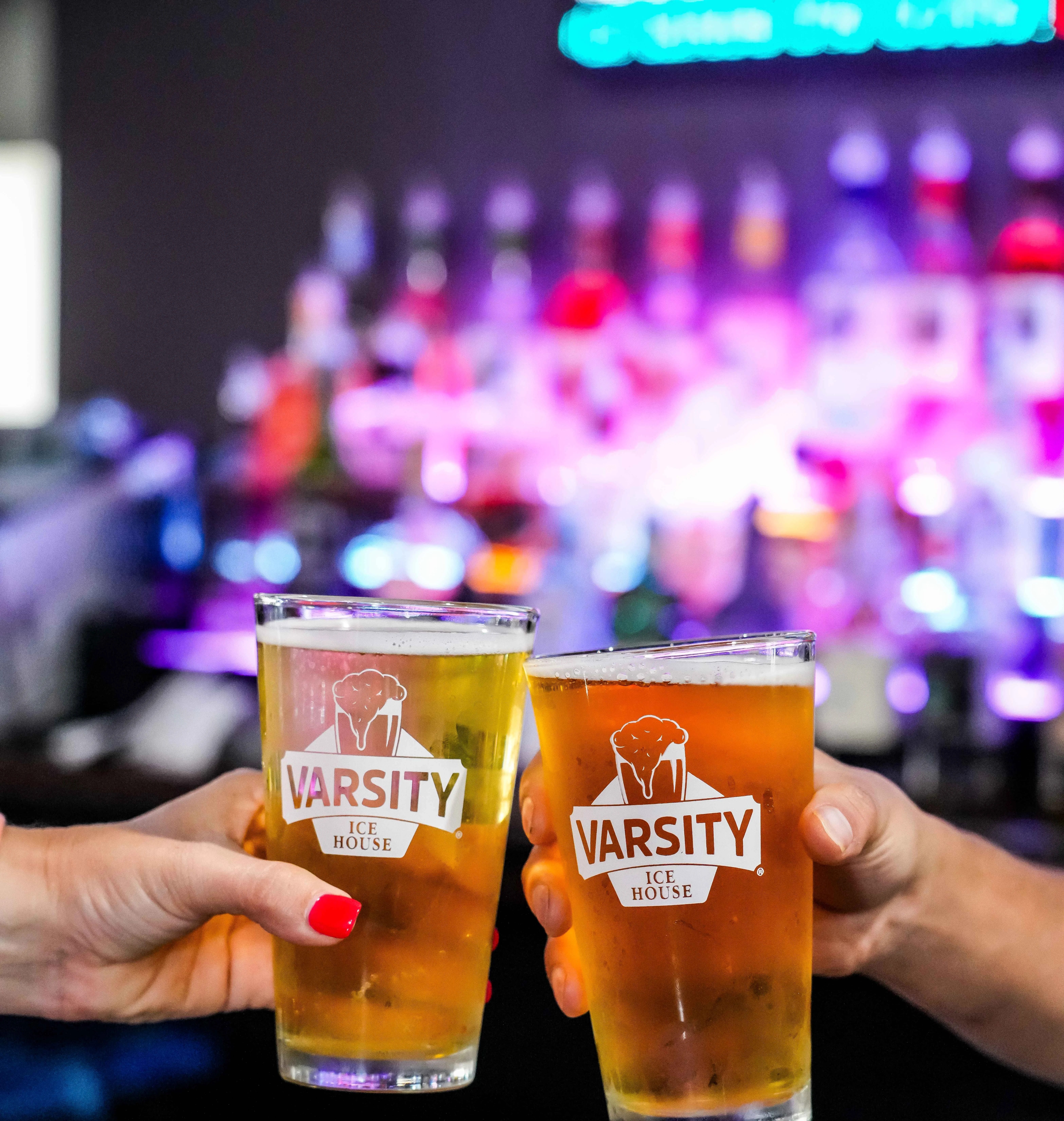 Cheers with two pints of beer at a lively bar