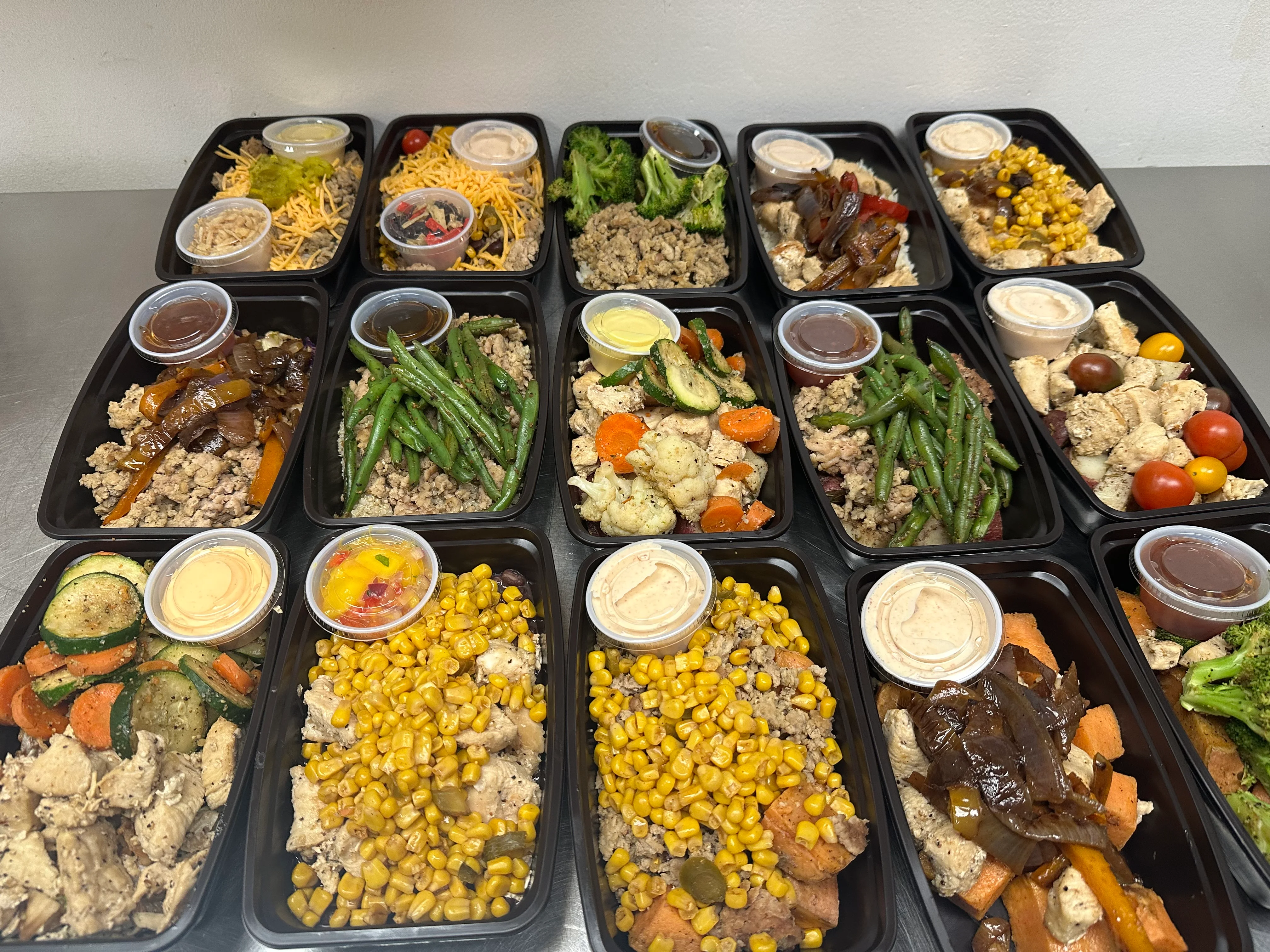 Healthy meal prep containers with assorted vegetables and proteins