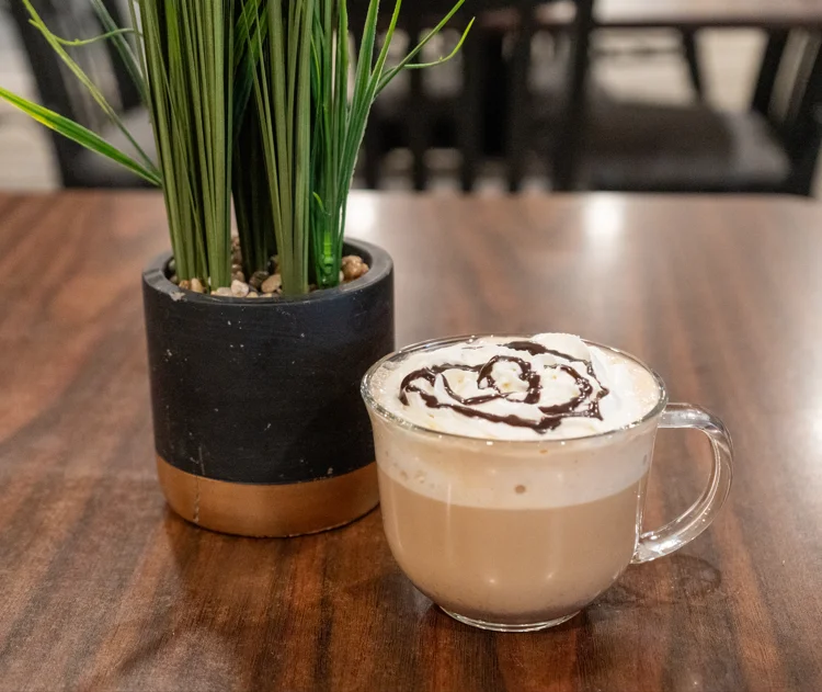 Creamy latte topped with whipped cream and chocolate drizzle