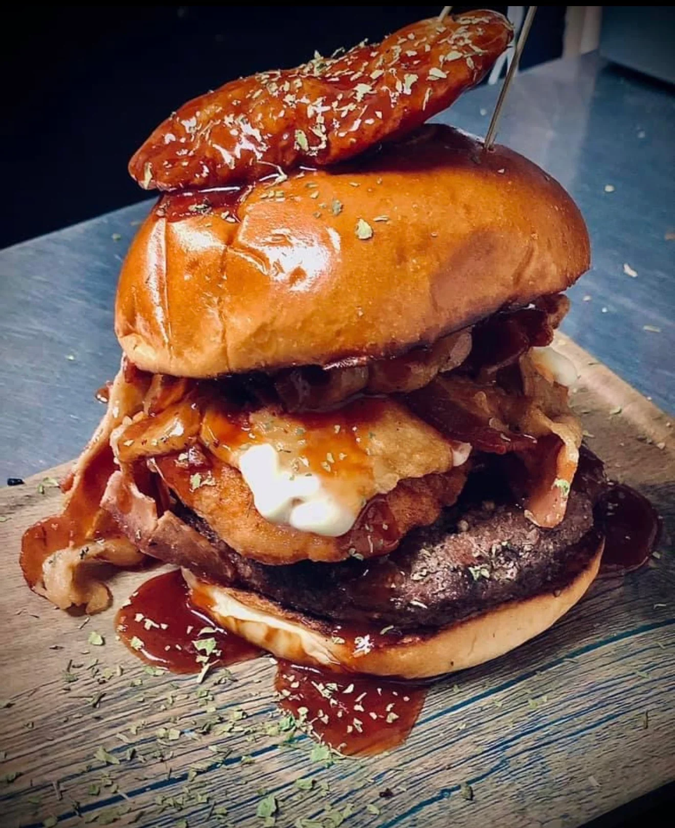 Delicious burger with toppings served on a wooden board