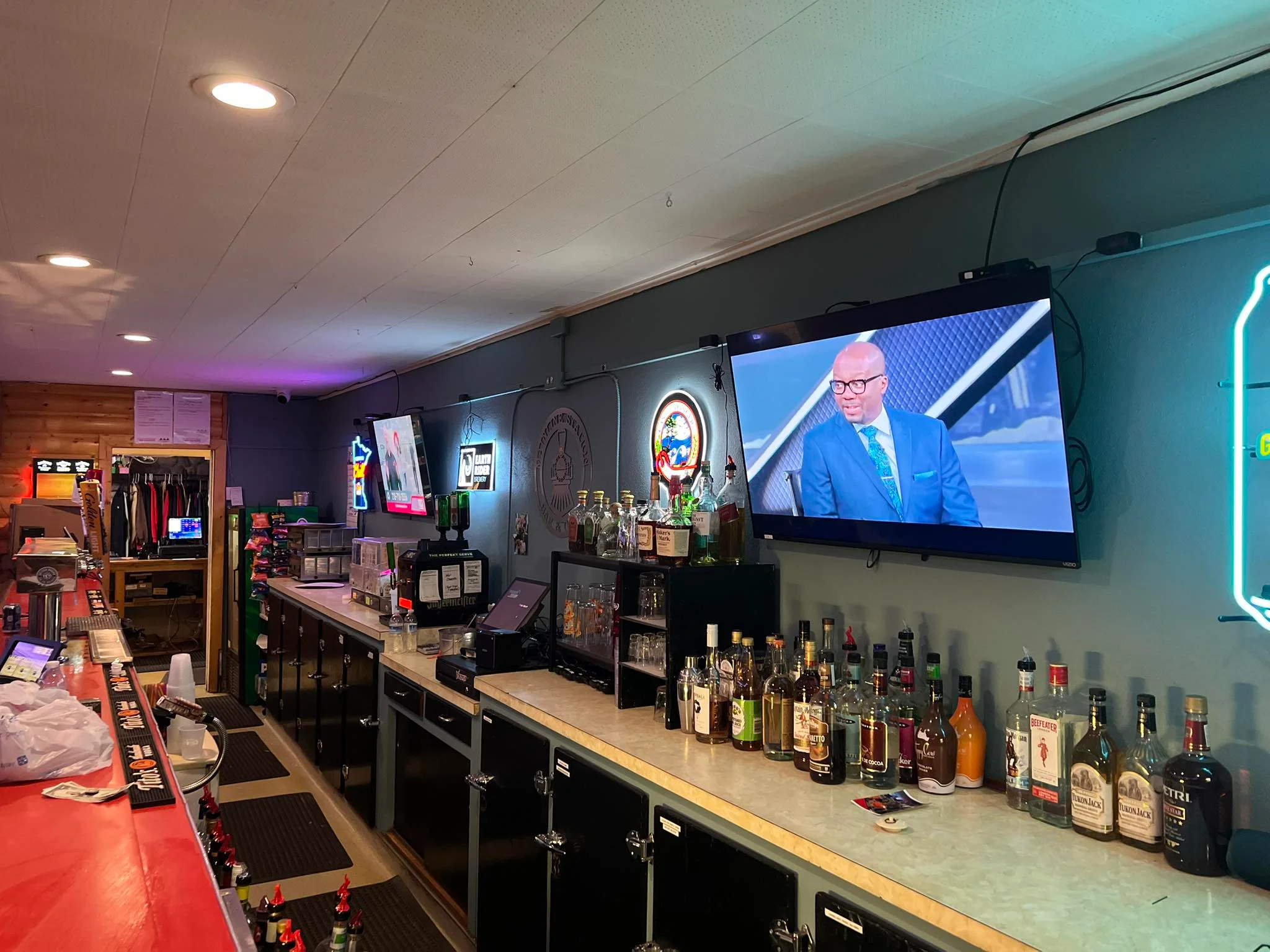 Cozy bar interior with a TV and a variety of spirits