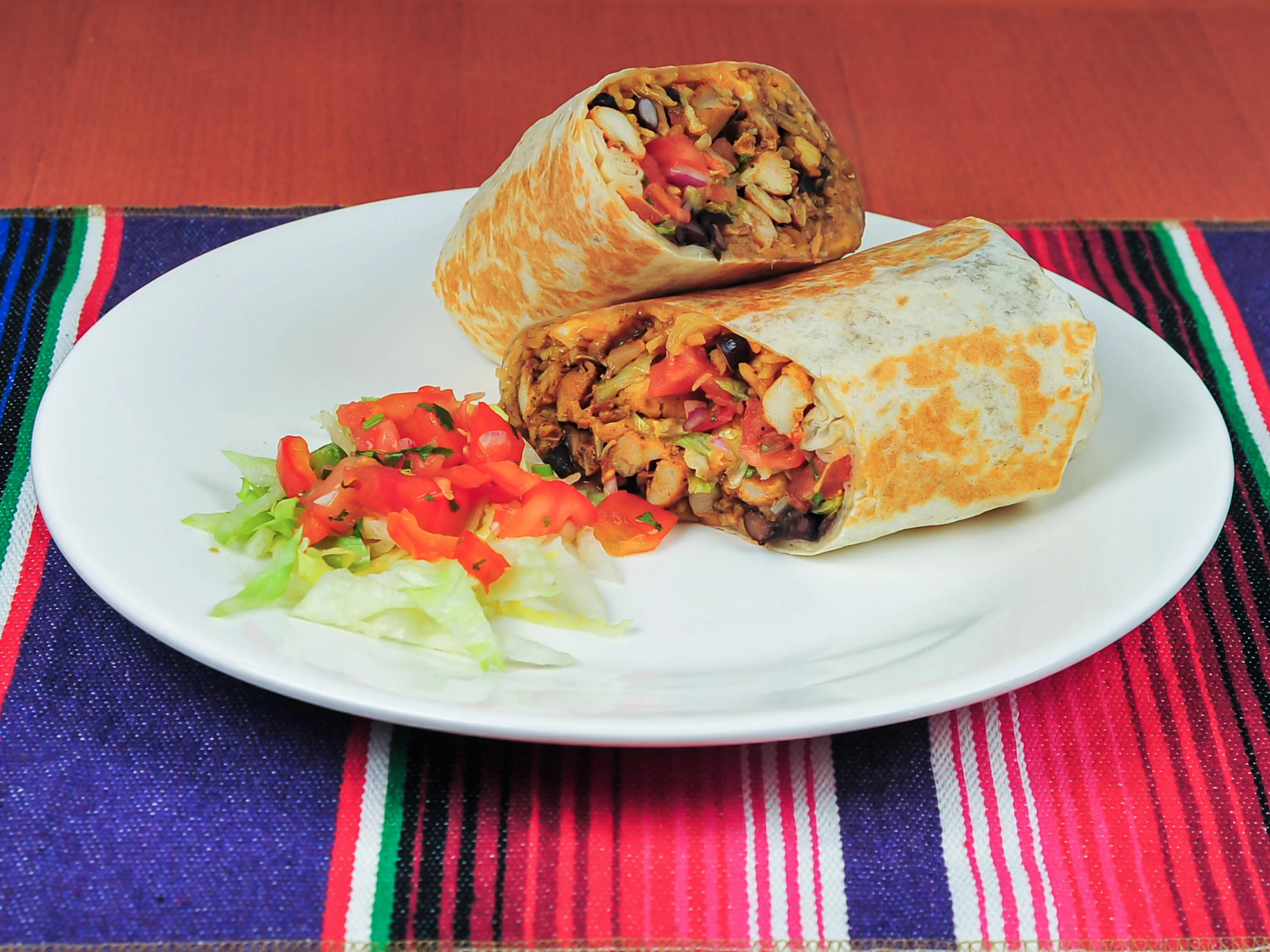 Delicious burrito served with fresh salsa and lettuce