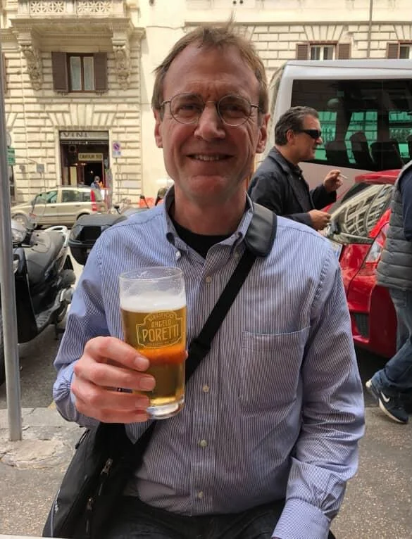 Man enjoying a beer at a street cafe in Italy
