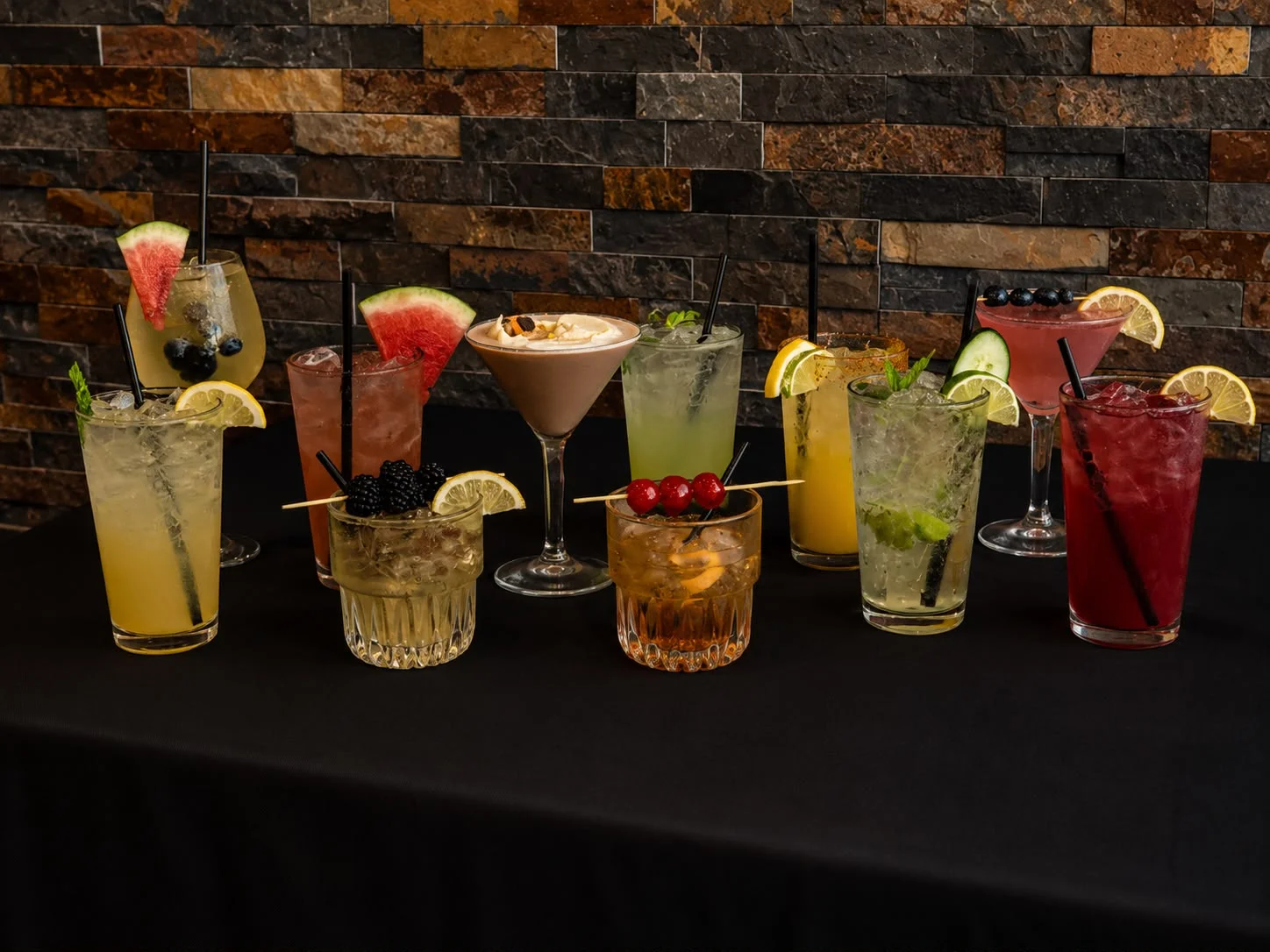 Colorful array of cocktails on a black table