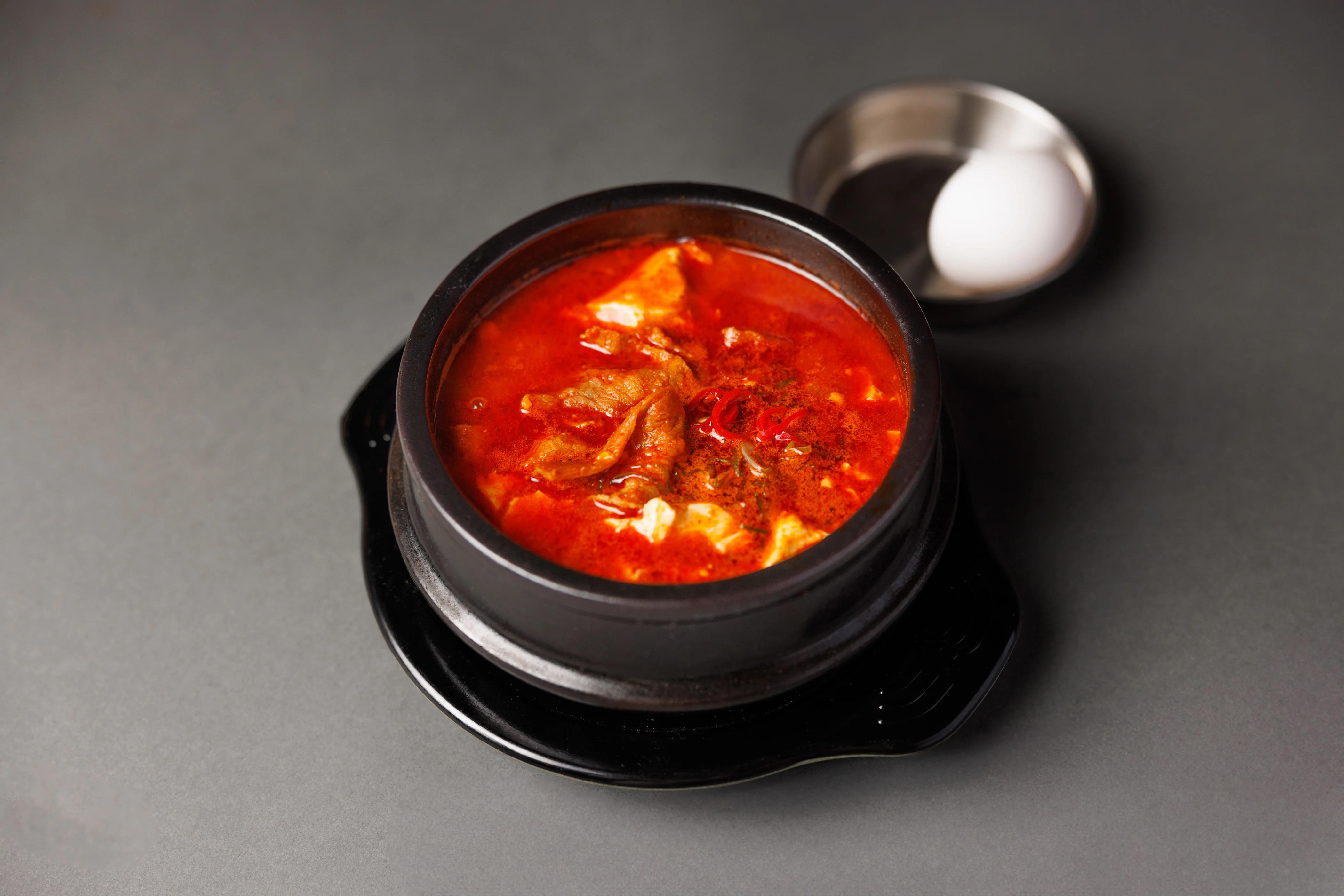 Spicy Korean kimchi jjigae in a stone pot