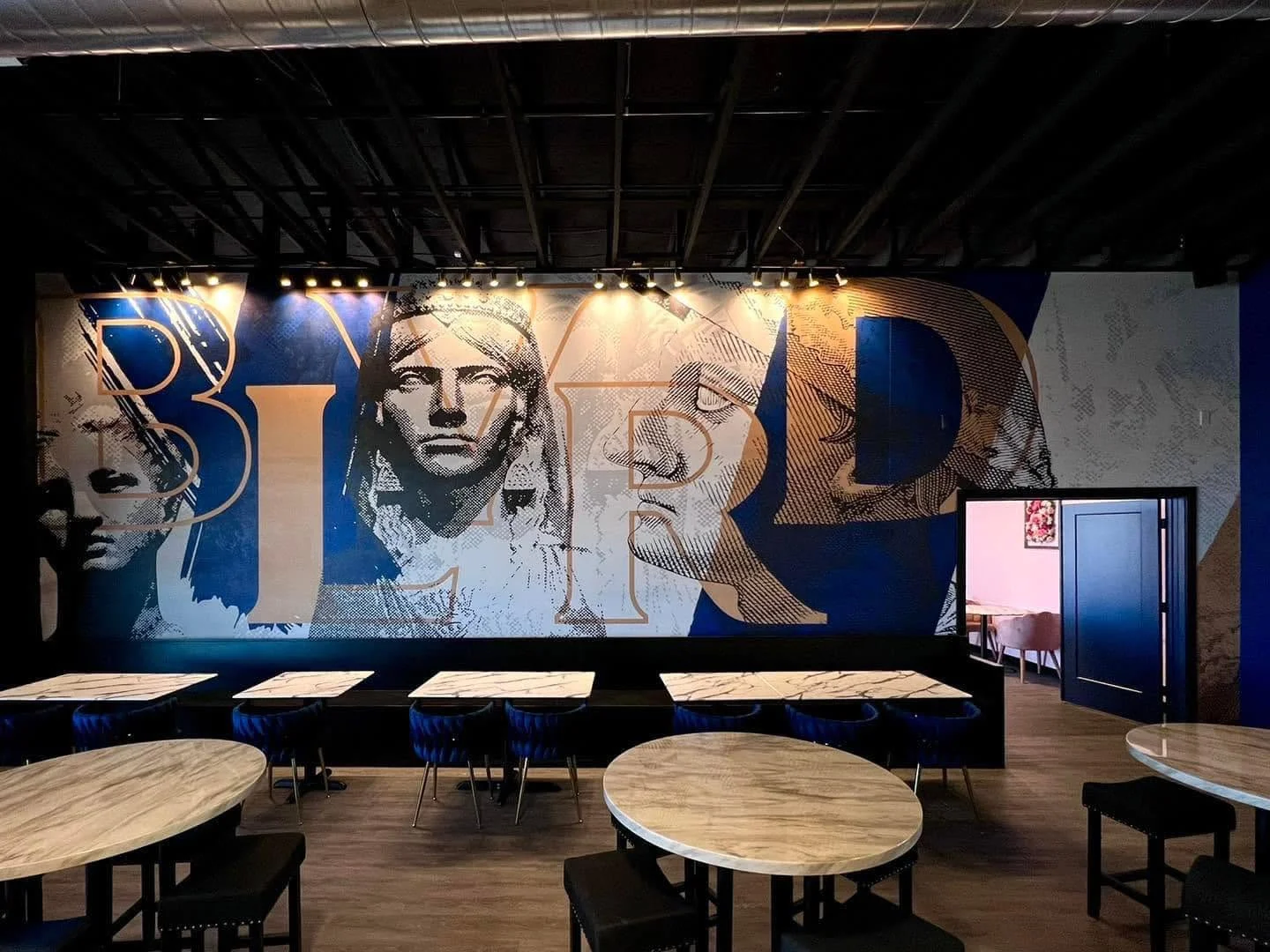 Stylish restaurant interior with artistic mural and modern seating