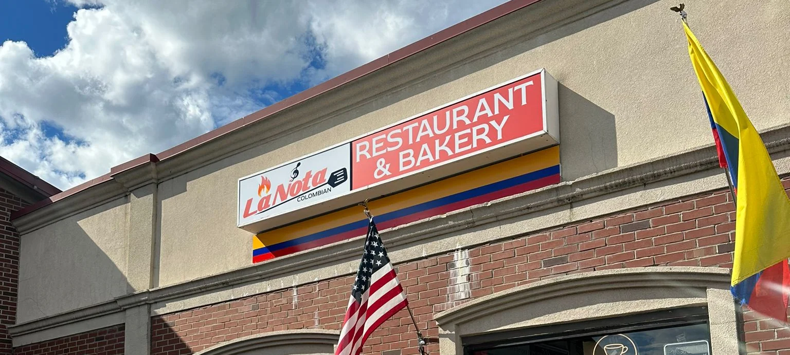 Exterior of La Nota Restaurant & Bakery with Colombian flags and signage