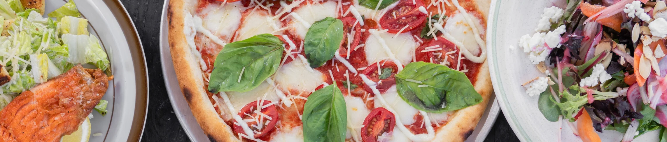 Assorted pizzas and salad in a vibrant restaurant setting