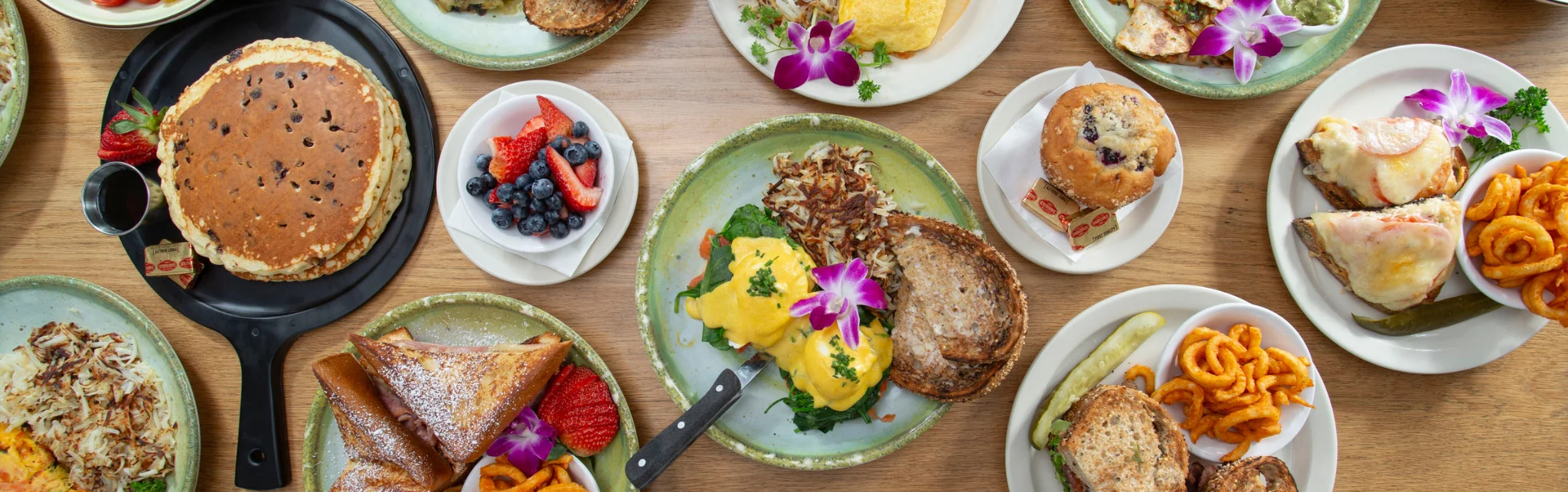 Brunch spread featuring pancakes, eggs benedict, and fresh fruit