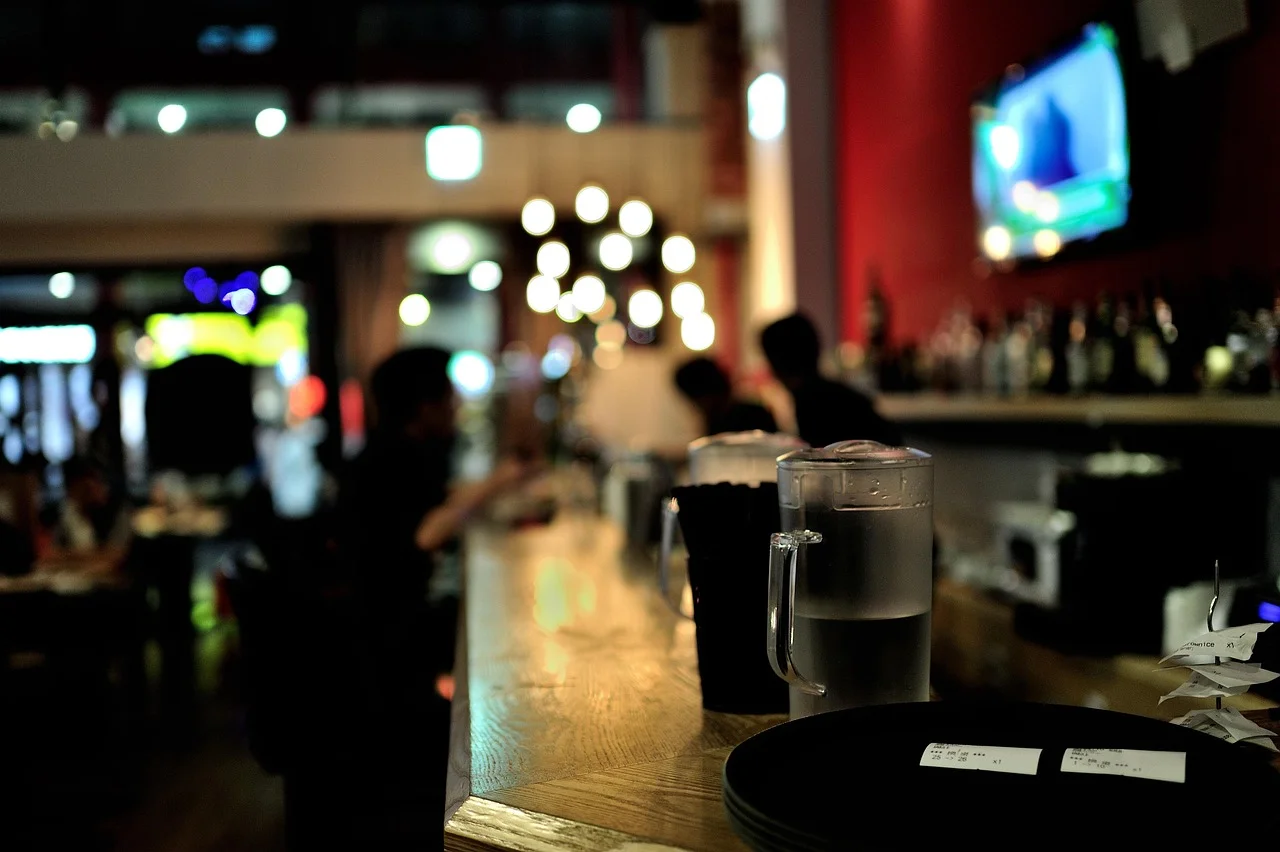 Modern bar interior with water pitchers and warm lighting