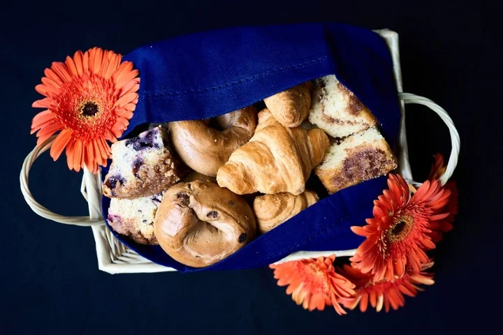 Assorted pastries in a basket with vibrant flowers